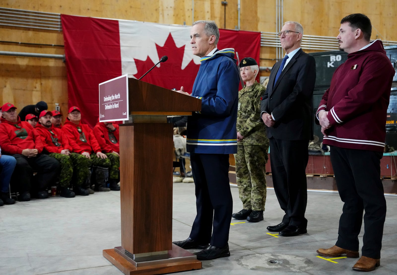 Canada Prime Minister Mark Carney, left to right, makes an announcement as Chief of Defence Staff Gen. Jennie Carignan, Defence Minister Bill Blair and Nunavut Premier P.J. Akeeagok look on at a Canadian Armed Forces forward-operating location in Iqaluit, Nunavut, on Tuesday, March 18, 2025. (Sean Kilpatrick/The Canadian Press via AP)