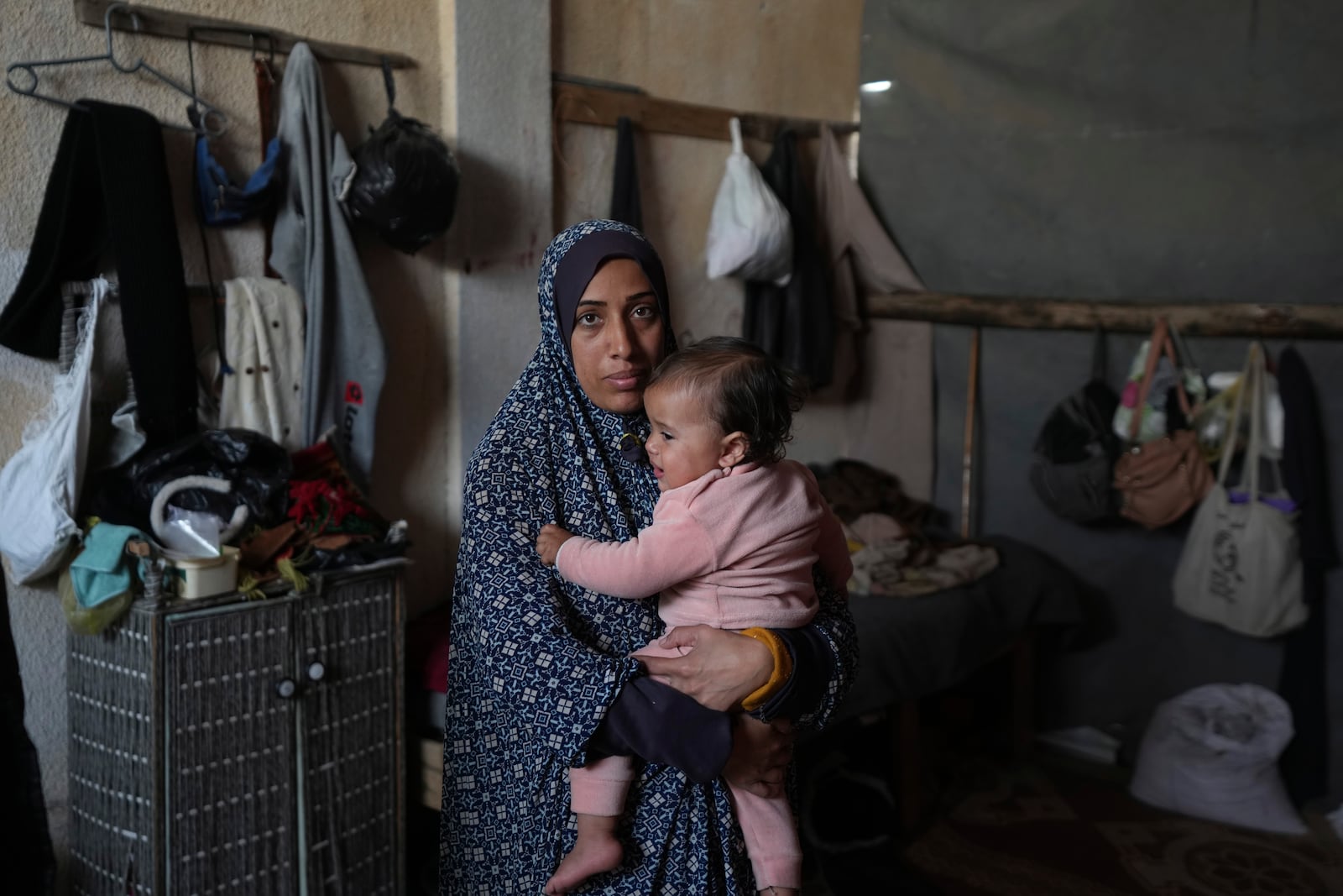 Rola Saqer holds her daughter, Massa Zaqout, who was born on the first day of the war in Gaza, in the family tent in Deir al-Balah, Gaza Strip, Tuesday, Jan. 14, 2025. (AP Photo/Abdel Kareem Hana)