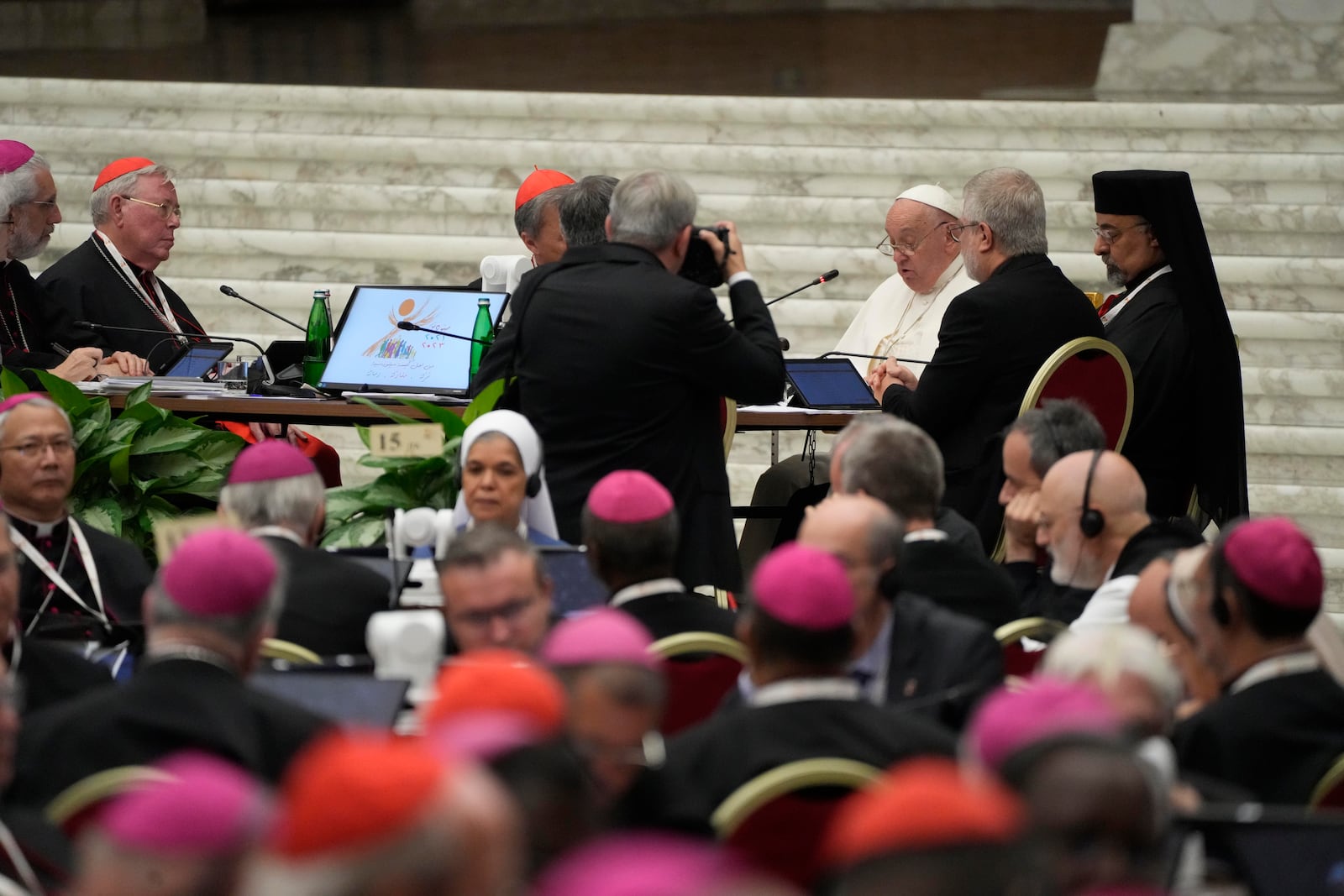 Pope Francis, background right attends the works of the second session of the 16th General Assembly of the Synod of Bishops in the Paul VI hall, at the Vatican, Saturday, Oct. 26, 2024. (AP Photo/Gregorio Borgia)