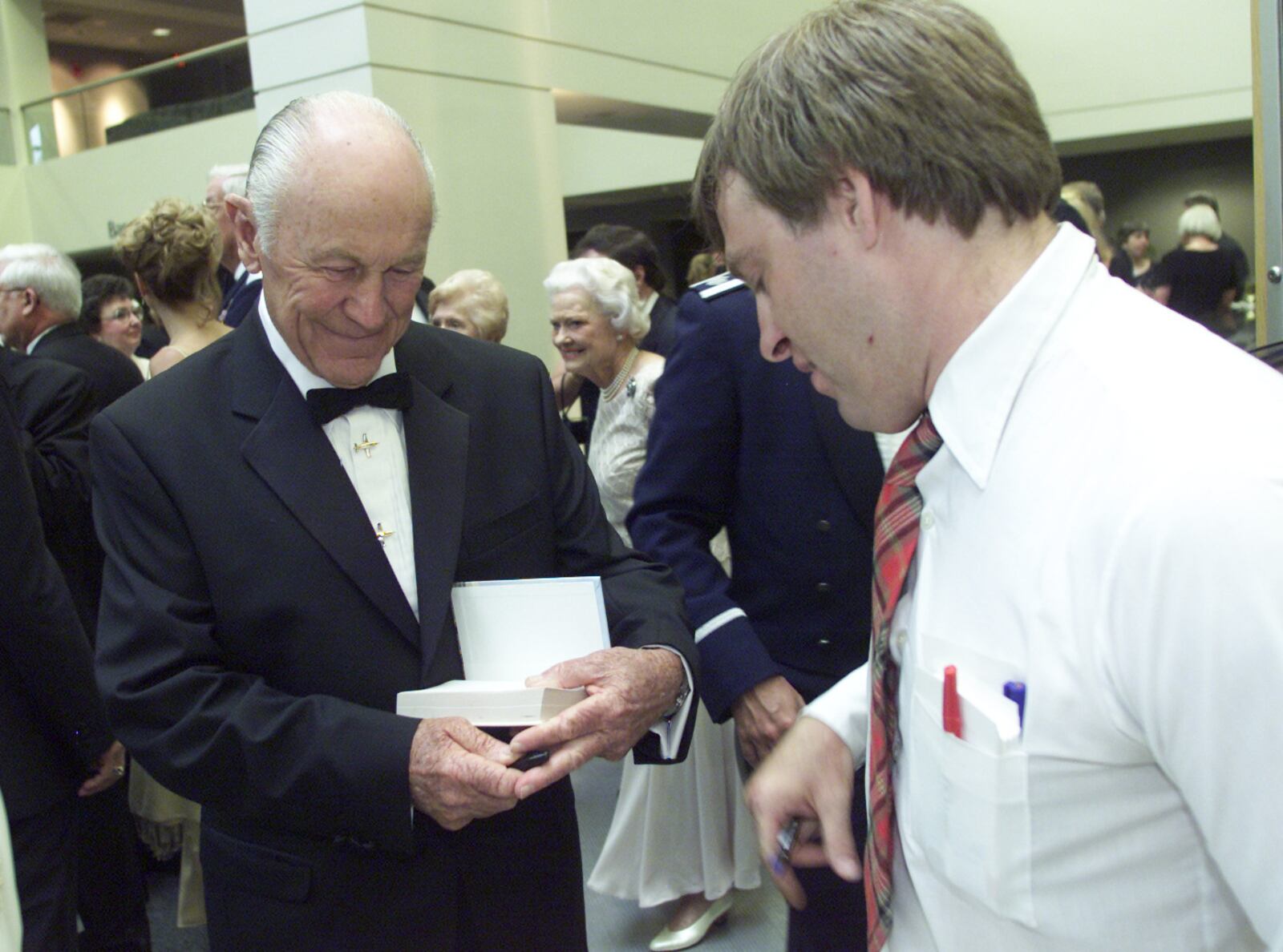 0722Halloffame-p1 Famous avaition pioneer Gen. Chuck Yeager, left, autographs his book for John Bossart Jr., right, Sandusky, during a reception for the National Aviation Hall of Fame induction ceremony held at the Dayton Convention Center, Saturday.  Bossart said that he couldn't pass up making the trip to witness a piece of history in person. Hall of fame inductees include World War II ace Marion Carl, test pilot Joe Engle, World War II ace Robin Olds and Flightsafety International founder Albert Lee Uetschi.