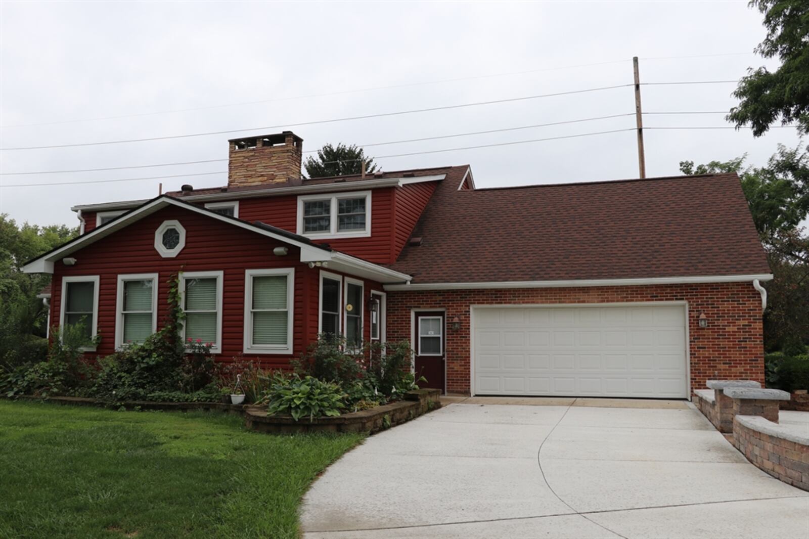 The great room or sunroom provides panoramic views of the back and side yards. A door opens out to a concrete driveway and patio extension. 