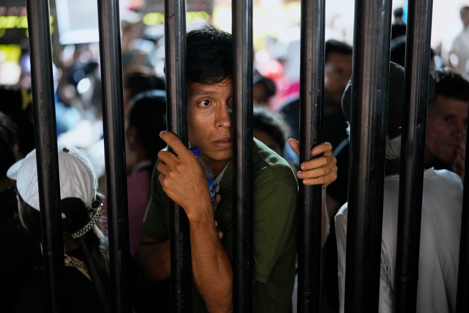 People displaced by violence in towns across the Catatumbo region, where rebels of the National Liberation Army, or ELN, have been clashing with former members of the Revolutionary Armed Forces of Colombia, line up to register for shelter at a stadium in Cúcuta, Colombia, Sunday, Jan. 19, 2025. (AP Photo/Fernando Vergara)