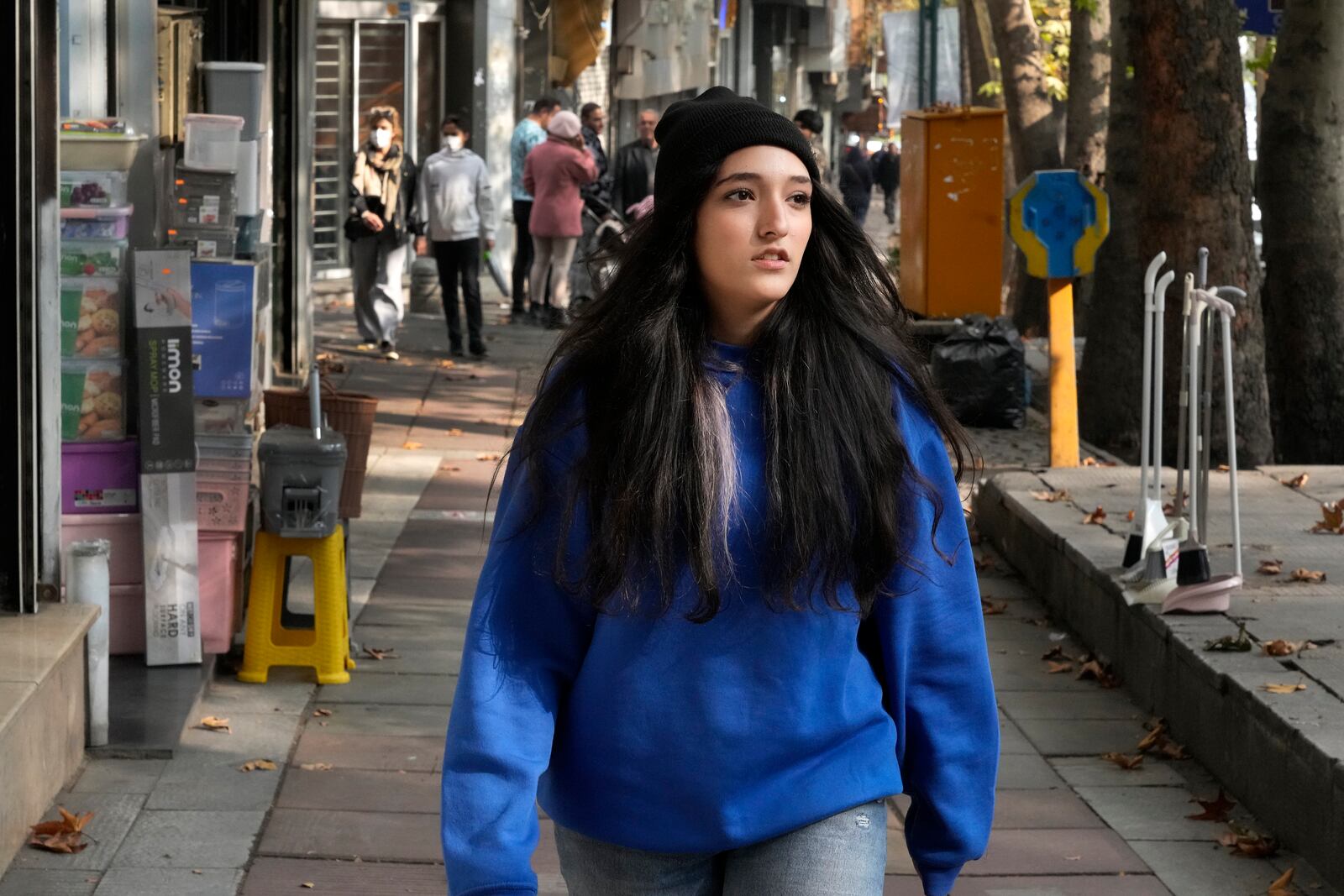 An Iranian woman, without wearing her mandatory Islamic headscarf, walks in northern Tehran, Iran, Friday, Nov. 15, 2024. (AP Photo/Vahid Salemi)