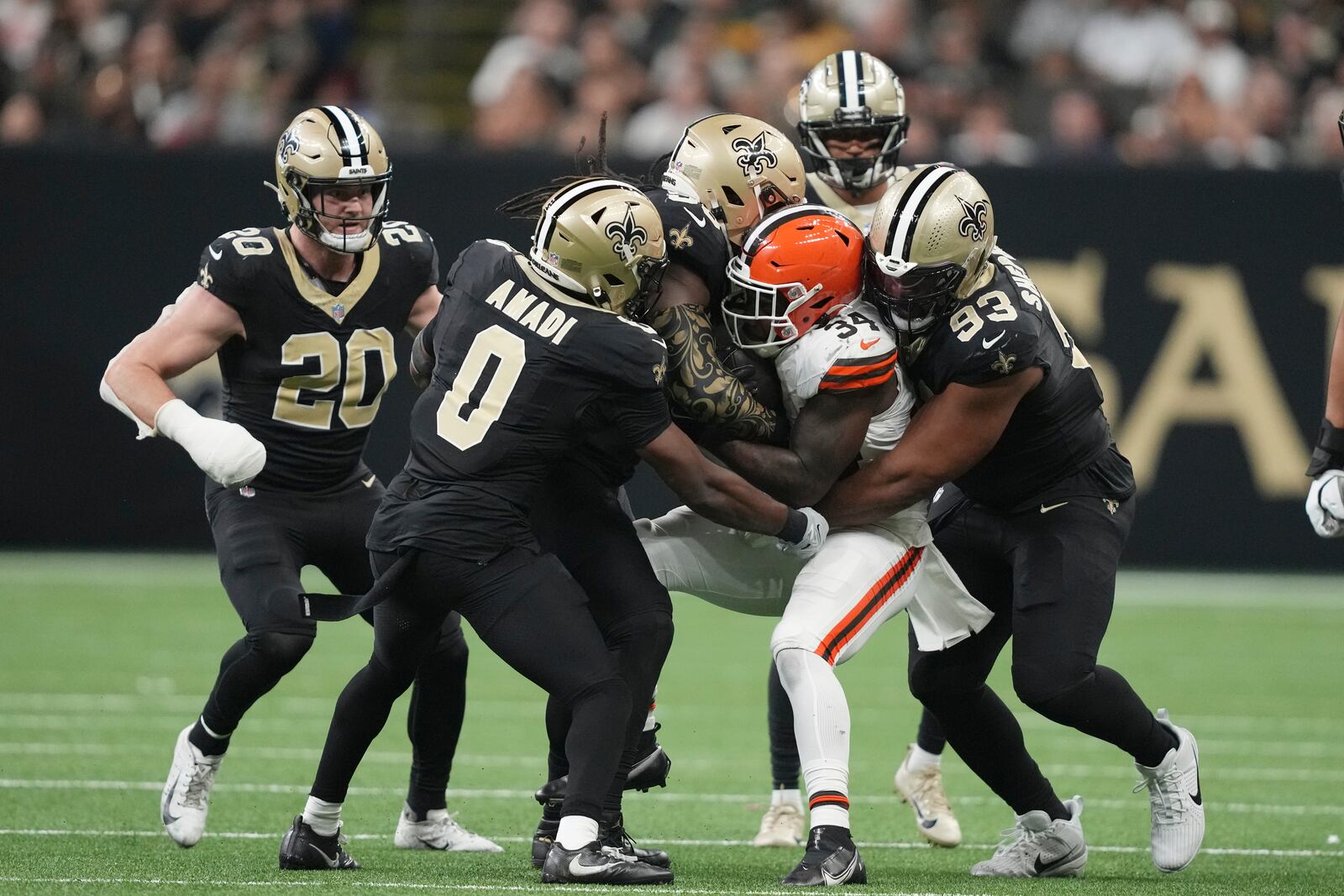 Cleveland Browns running back Jerome Ford (34) is tackled by a number of New Orleans Saints, including Ugo Amadi (0) and Nathan Shepherd (93) in the second half of an NFL football game in New Orleans, Sunday, Nov. 17, 2024. (AP Photo/Gerald Herbert)