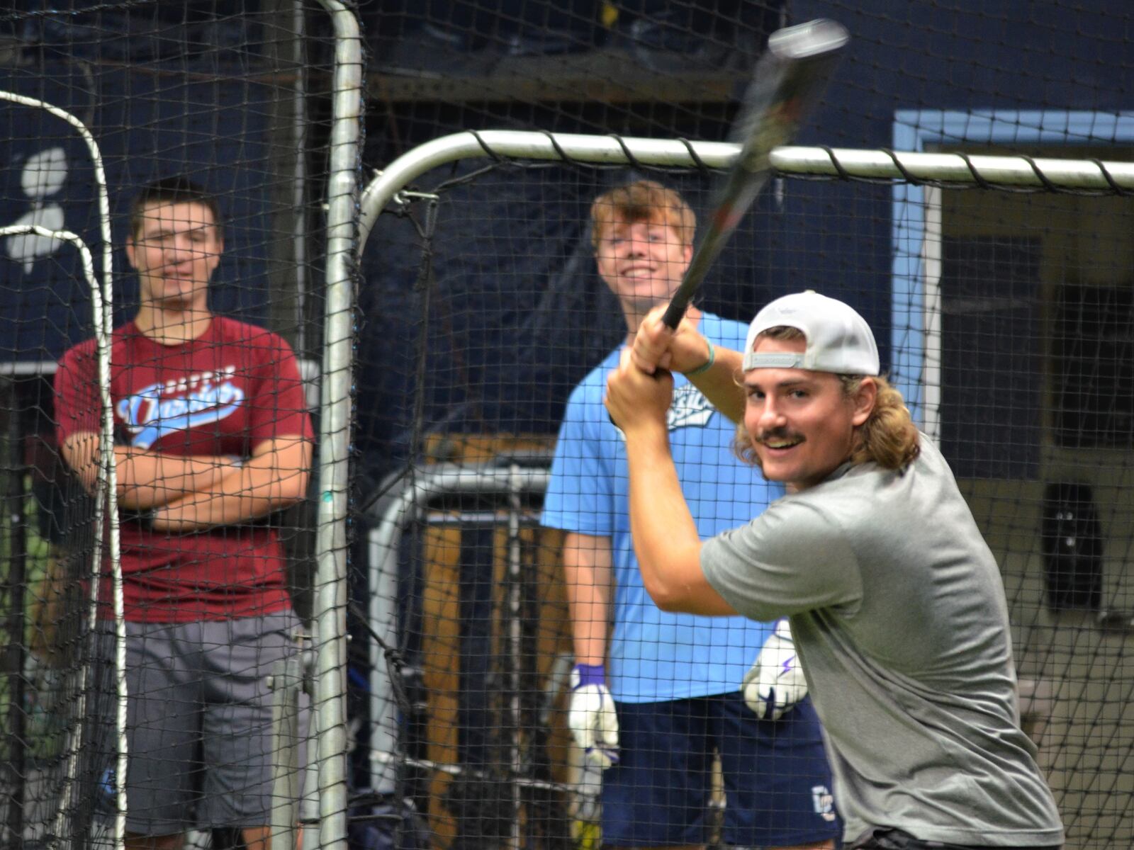 Matthew Roderer (left) and Luke Sutter (center) watch Angelo DeLeonardis go up to bat at the batting cages at Dayton Classics Baseball, August 20, 2023. LONDON BISHOP/STAFF