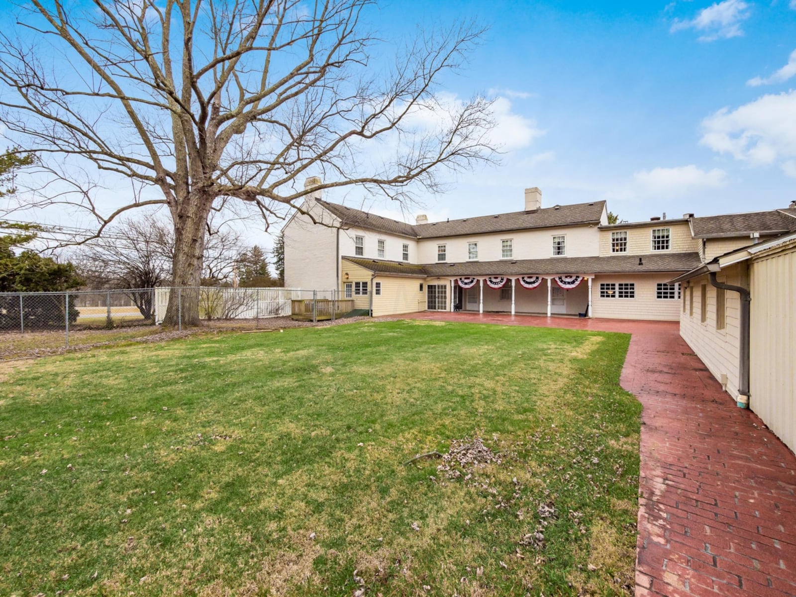 The rear has a partially covered patio and brick pavers that create walkways throughout the property. There is a partially fenced yard.