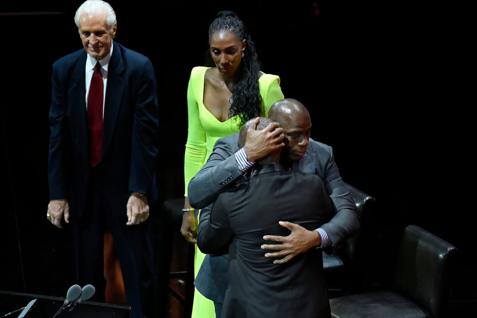 Magic Johnson, right, embraces Michael Cooper, front, as Pat Riley, left, and Lisa Leslie, top, look on during his enshrinement in the Basketball Hall of Fame, Sunday Oct. 13, 2024, in Springfield, Mass. (AP Photo/Jessica Hill)