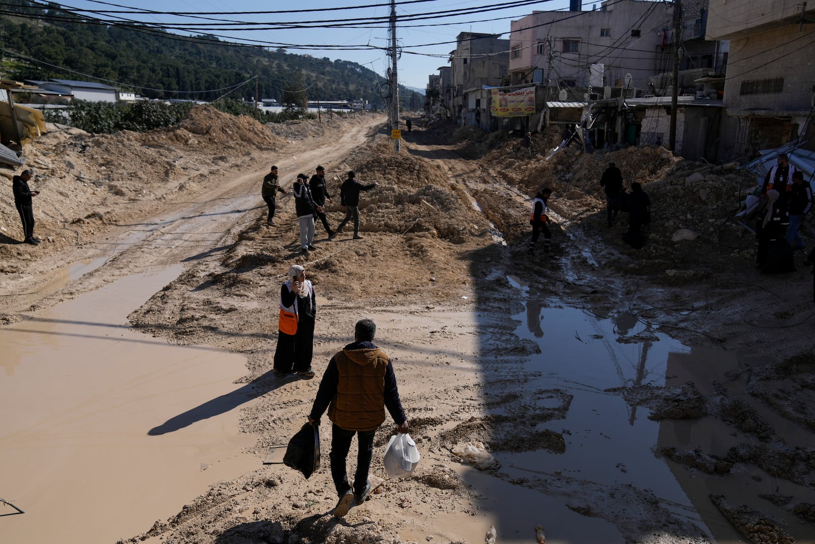 Residents of the West Bank urban refugee camp of Nur Shams evacuate their homes and carry their belongings as the Israeli military continues its operation in the area on Wednesday, Feb. 26, 2025. (AP Photo/Majdi Mohammed)