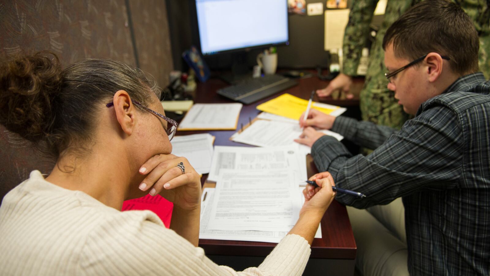 Melissa Ensey and Curtis Abbott sign their enlistment contracts at the Kansas City, Mo., Military Entrance Processing Station (MEPS). Ensey is Abbotts mother and they have both decided to enlist in the Navy together.