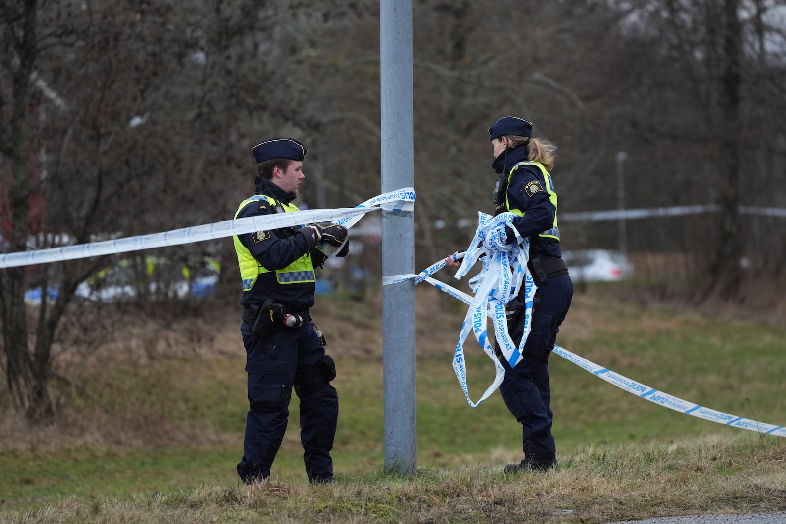 Police officers place a cordon around the scene of a shooting on the outskirts of Orebro, Sweden, Wednesday, Feb. 5, 2025. (AP Photo/Sergei Grits)