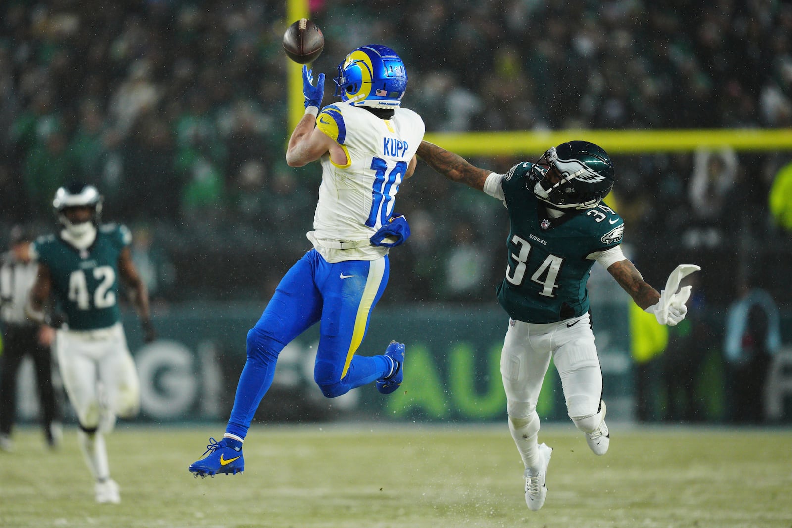 Los Angeles Rams wide receiver Cooper Kupp (10) makes a catch in front of Philadelphia Eagles cornerback Isaiah Rodgers (34) during the second half of an NFL football NFC divisional playoff game Sunday, Jan. 19, 2025, in Philadelphia. (AP Photo/Derik Hamilton)