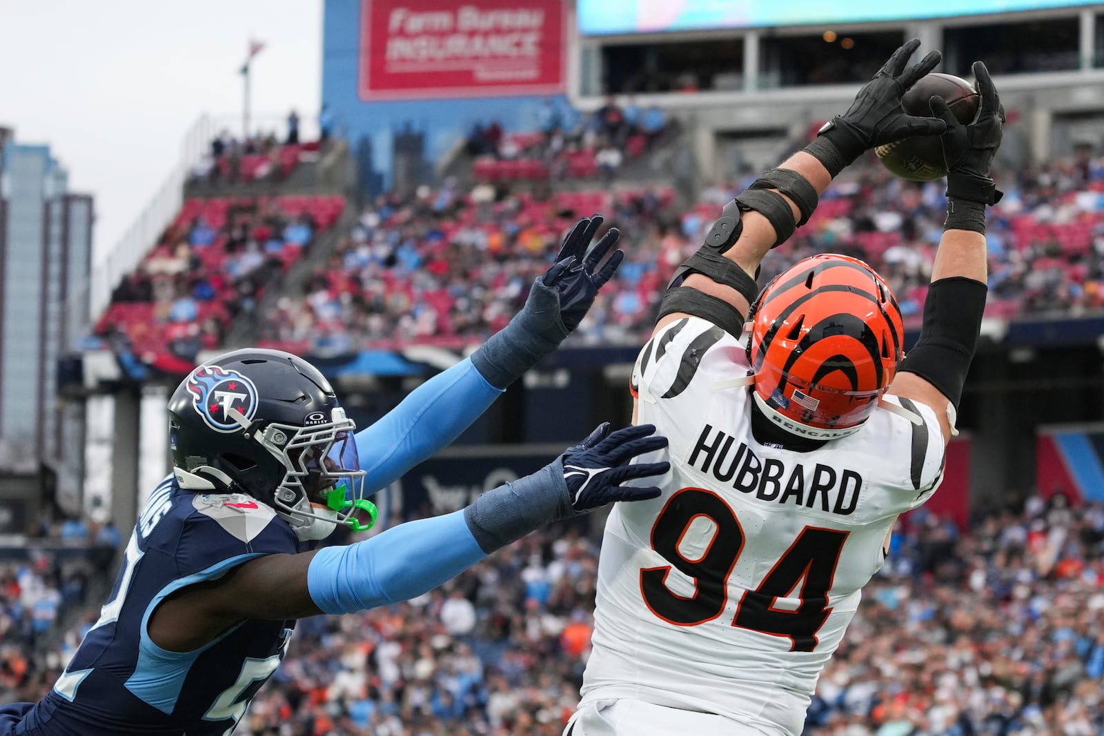 Cincinnati Bengals defensive end Sam Hubbard (94) catches a touchdown pass over Tennessee Titans linebacker James Williams during the first half of an NFL football game Sunday, Dec. 15, 2024, in Nashville, Tenn. (AP Photo/George Walker IV)