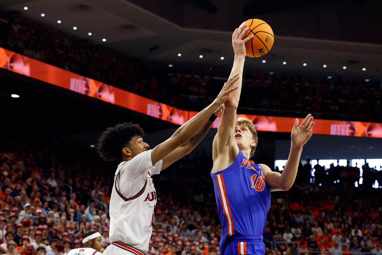 Florida forward Thomas Haugh, right, is fouled by Auburn guard Chad Baker-Mazara, left, as he looks to shoot during the first half of an NCAA college basketball game, Saturday, Feb. 8, 2025, in Auburn, Ala. (AP Photo/Butch Dill)