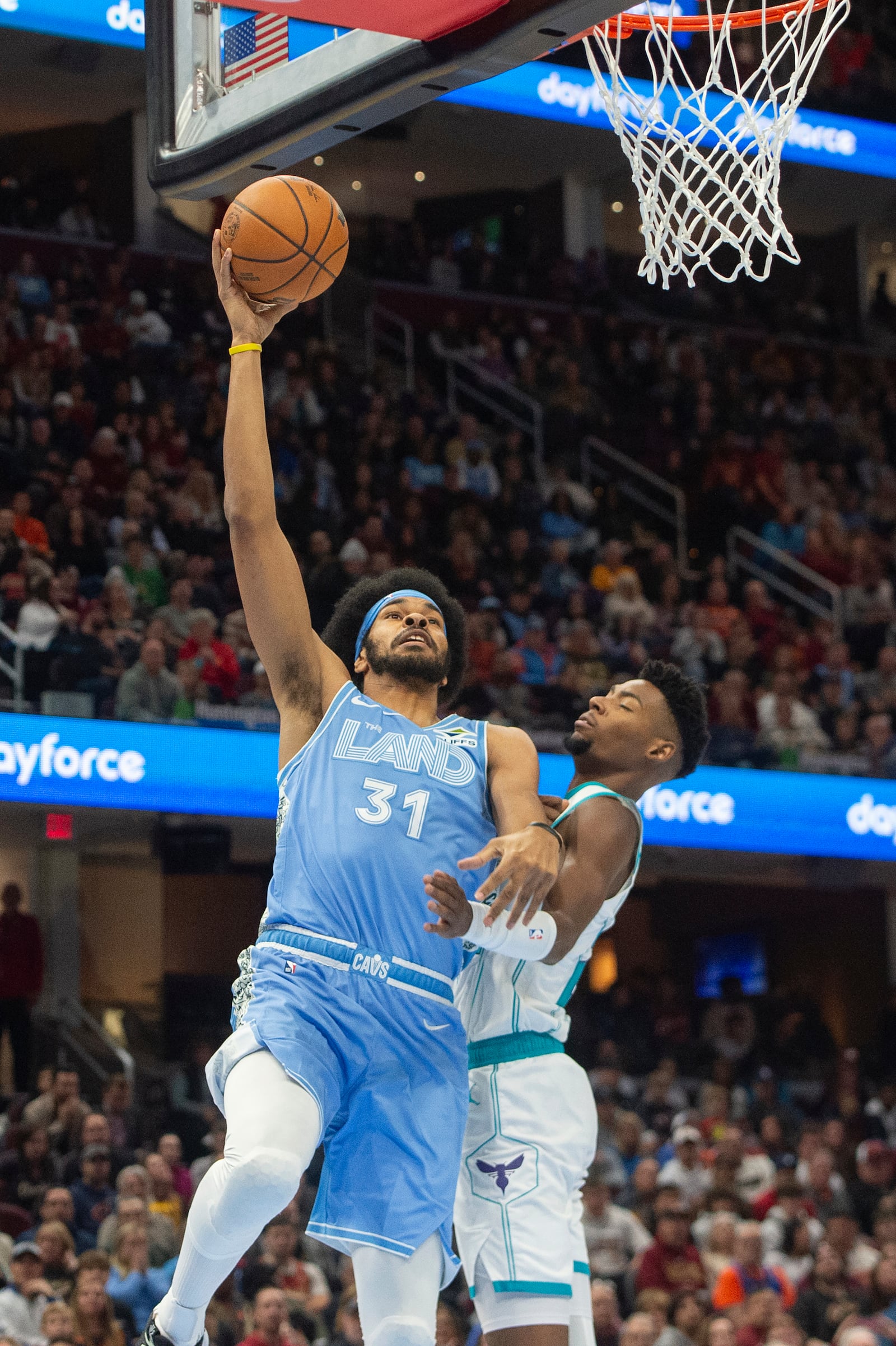 Cleveland Cavaliers' Jarrett Allen (31) drives to the basket as Charlotte Hornets' Brandon Miller, right, defends during the first half of an NBA basketball game in Cleveland, Sunday, Nov 17, 2024. (AP Photo/Phil Long)