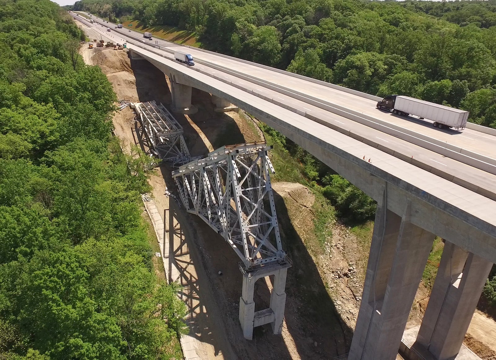 The third time was not quite the charm ODOT officials were expecting as contractors tried again to take down the remaining steel structure of the Jeremiah-Morrow Bridge this past weekend.  For the third time, I-71 was shut down on a Sunday morning to allow explosive demolition work to be performed next to new concrete bridges that carry traffic over the Little Miami River Valley in Warren County.  One stubborn steel expanse on the north side of the old bridge failed to collapse in the last round of explosive charges, leaving large pieces of the structure intact and still attached to the concrete piers.  Chunks of steel structure from the south side of the bridge are being trucked away daily.     TY GREENLEES / STAFF