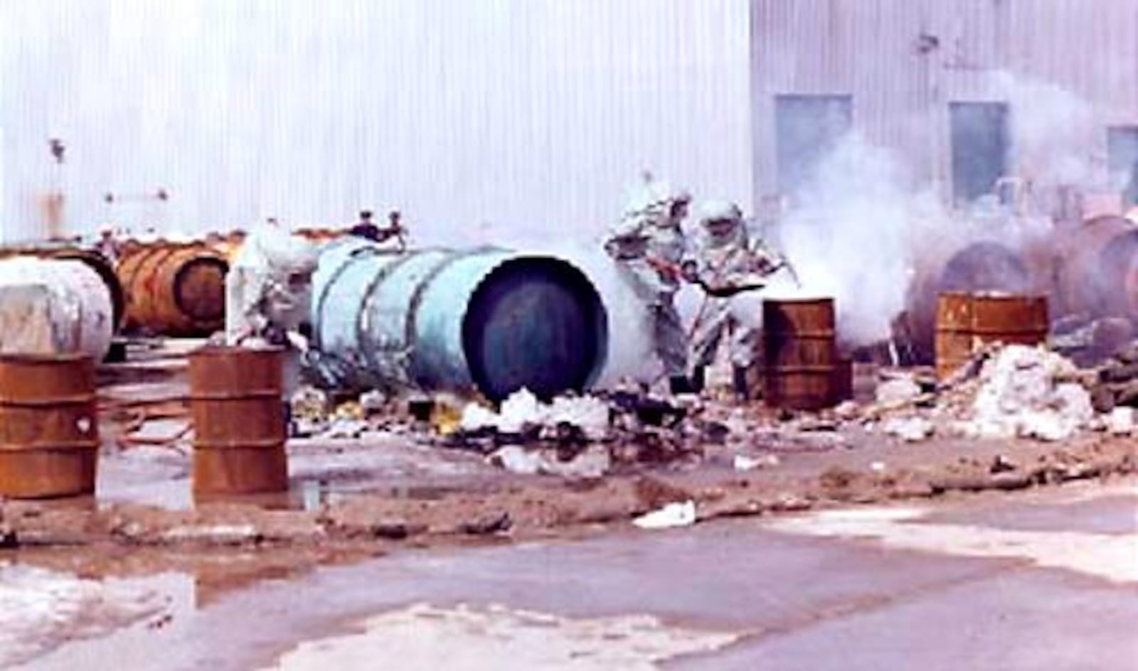 Workers clean up following the March 1978 rupture of a 14-ton cylinder of liquid uranium hexafluoride that was dropped at the Portsmouth Gaseous Diffusion plant. The subsequent leak nearly emptied the cylinder, releasing 21,125 pounds of radioactive, toxic uranium hexafluouride.