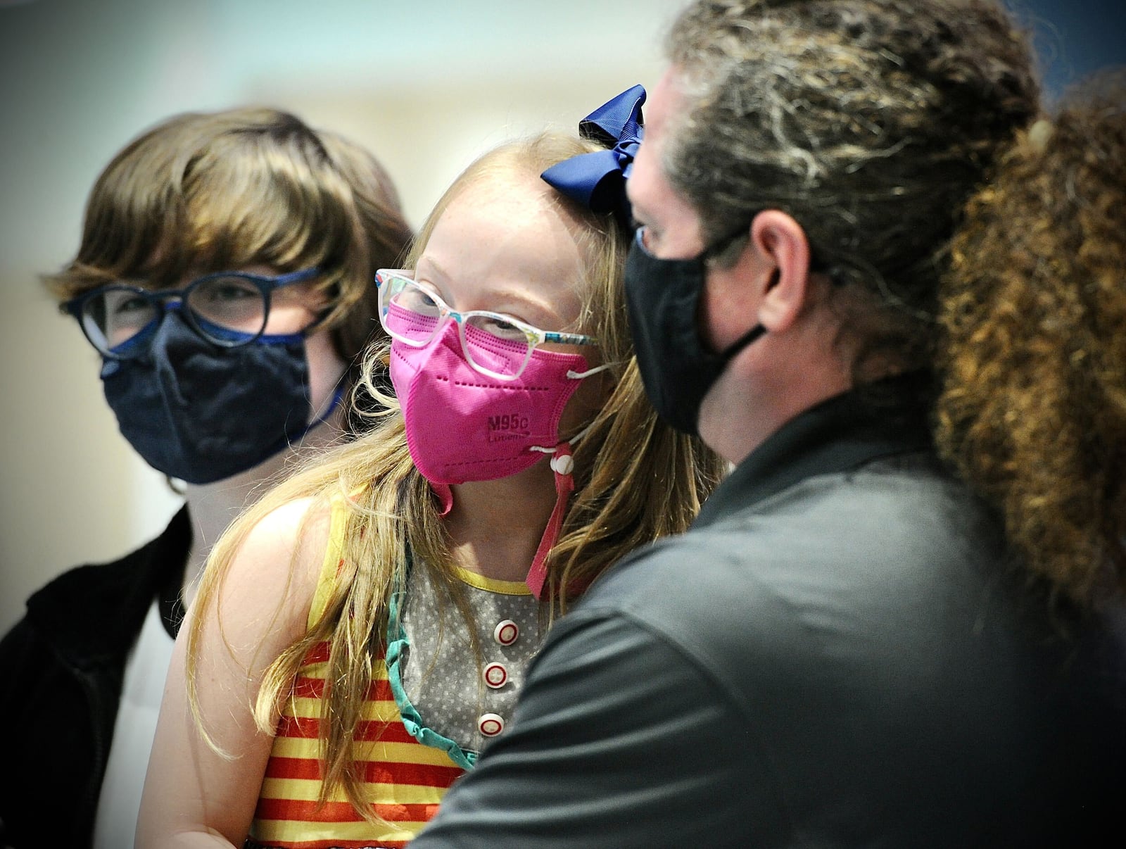 Joy Minor, age 9,  waits with brother, Jay, right and father, Paul, left for her COVID-19 vaccine at Dayton Childern's Monday, Nov. 8, 2021. MARSHALL GORBY\STAFF