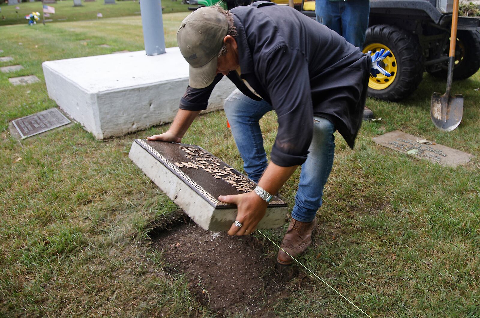 Rob Kelly, a member of the Ferncliff Cemetery grounds crew, places the grave marker for Medal of Honor winner and Clark County native James Richard Ward in place in the World War II veterans section at Ferncliff Wednesday, July 10, 2024. The remains of Ward, who was killed on the USS Oklahoma at Pearl Harbor, were recently recovered and identified. His family asked for him to be buried at Arlington Cemetery in Washington D.C. and according to military rules, a veteran can only have one military grave marker and the marker that was placed at Ferncliff was removed. The cemetery recently had another marker made and today it was placed where the old marker was located. BILL LACKEY/STAFF