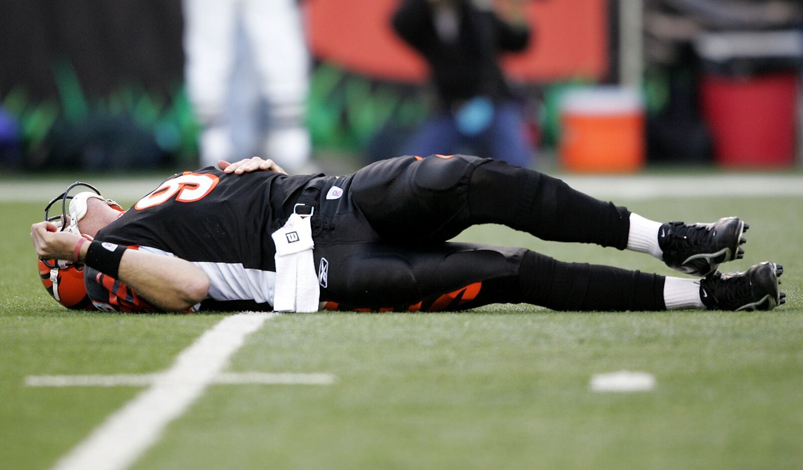 CINCINNATI - JANUARY 08:  Quarterback Carson Palmer #9 of the Cincinnati Bengals lays on the ground after being hit in the knee on the first drive of the AFC Wild Card Playoff Game against the Pittsburgh Steelers at Paul Brown Stadium on January 8, 2006 in Cincinnati, Ohio.   The Steelers defeated the Bengals 31-17.  (Photo by Andy Lyons/Getty Images)