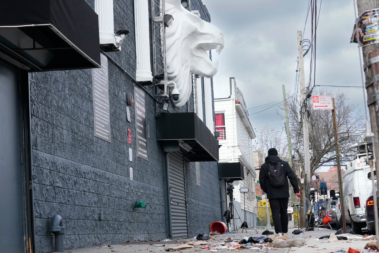 Members of the media work in front of the nightclub Amazura, left, in the Queens borough of New York, Thursday, Jan. 2, 2025. (AP Photo/Seth Wenig)