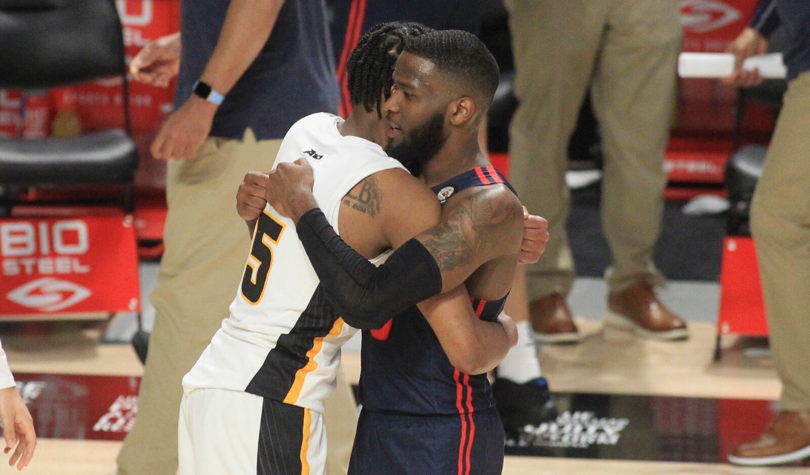 Dayton's Jalen Crutcher hugs Virginia Commonwealth's Bones Hyland after their Atlantic 10 tournament game on Friday, March 5, 2021, at the Siegel Center in Richmond, Va. David Jablonski/Staff