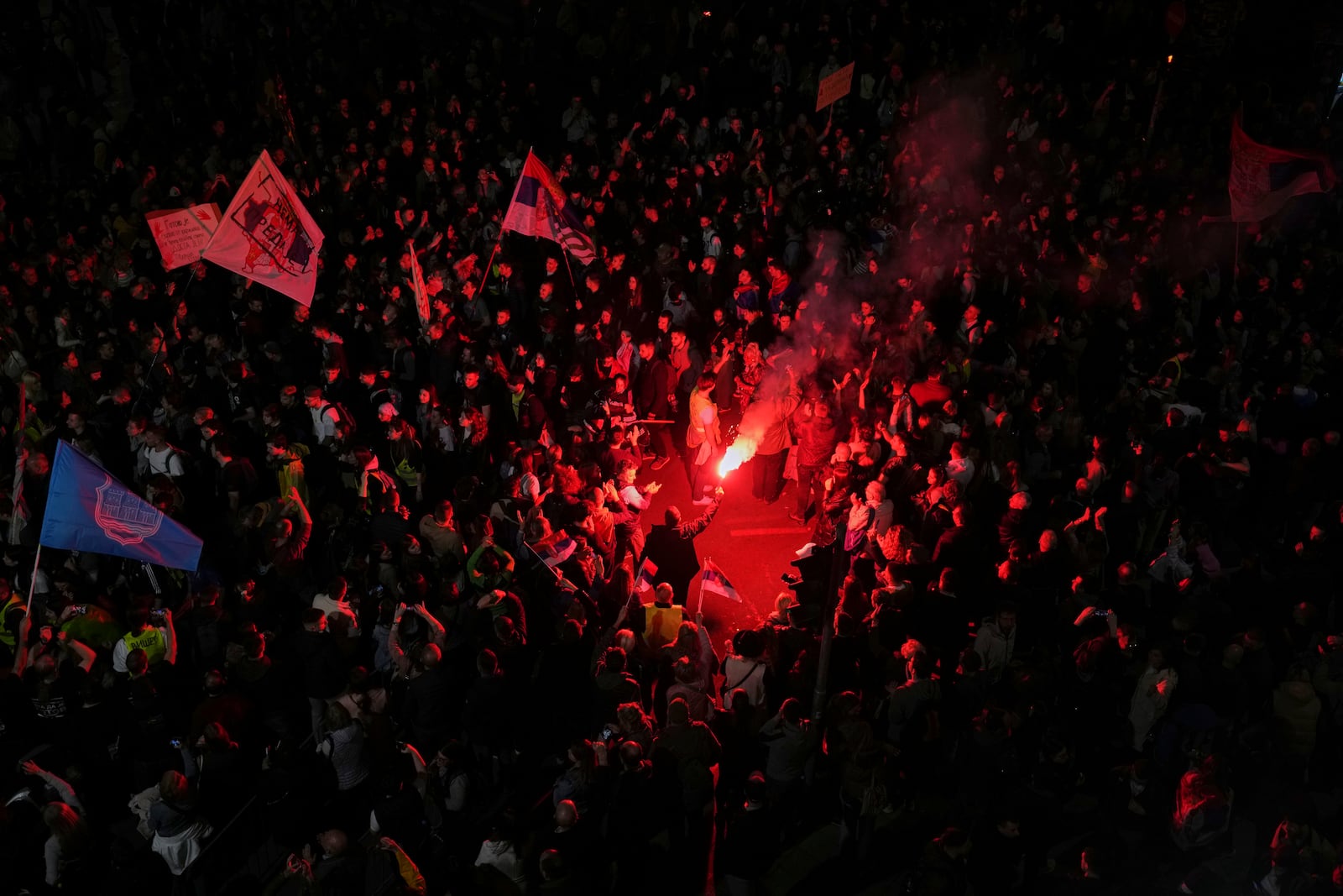 Protesters light flares as they gather ahead of a major rally this weekend in downtown Belgrade, Serbia, Friday, March 14, 2025. (AP Photo/Darko Vojinovic)