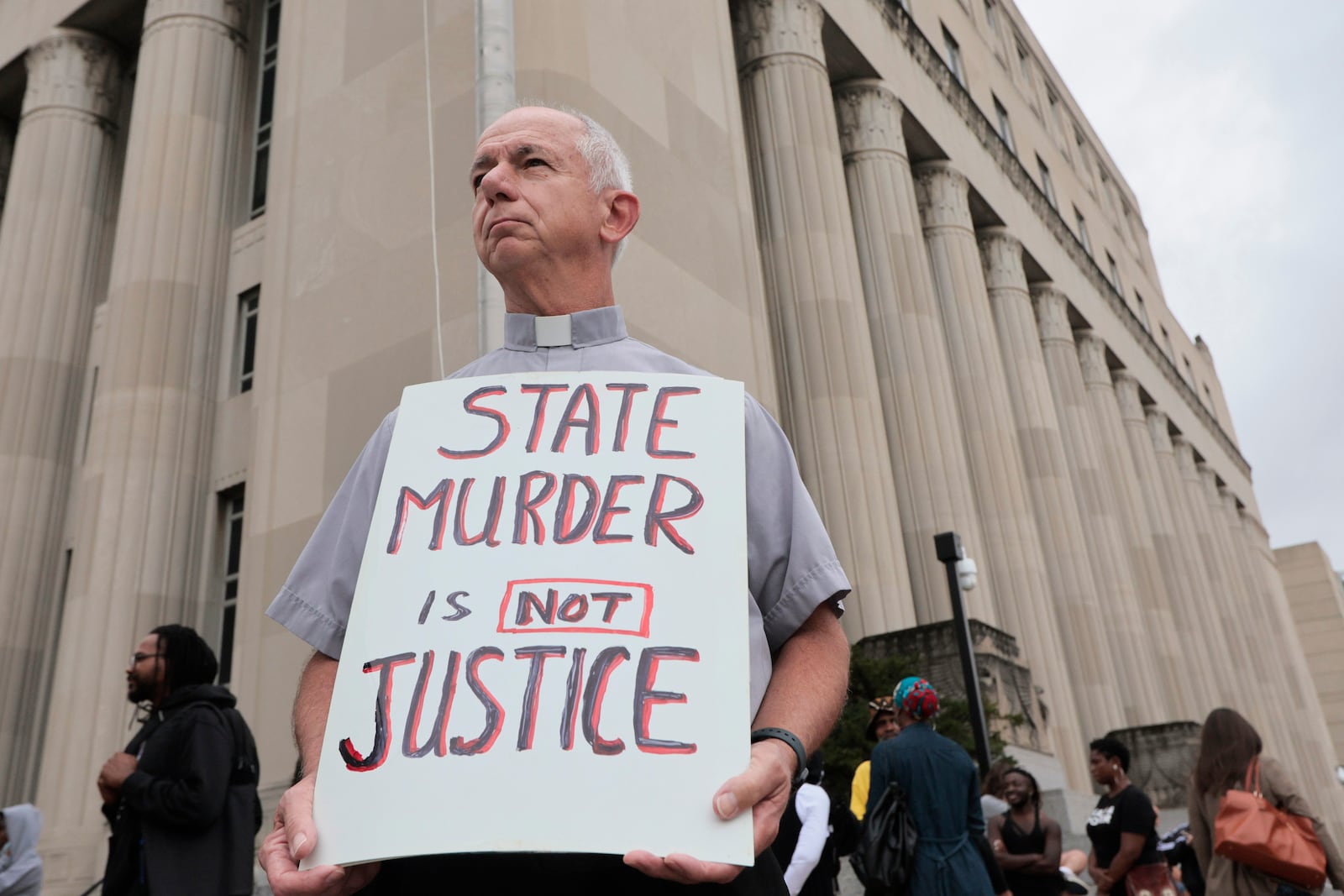 FILE - Deacon Dave Billips, with the Office of Peace and Justice with the St. Louis Archdiocese, holds a sign as he stands with protesters holding space to halt the execution of Marcellus Williams Tuesday, Sept. 24, 2024, outside the Carnahan Courthouse in St. Louis. (Laurie Skrivan/St. Louis Post-Dispatch via AP, File)