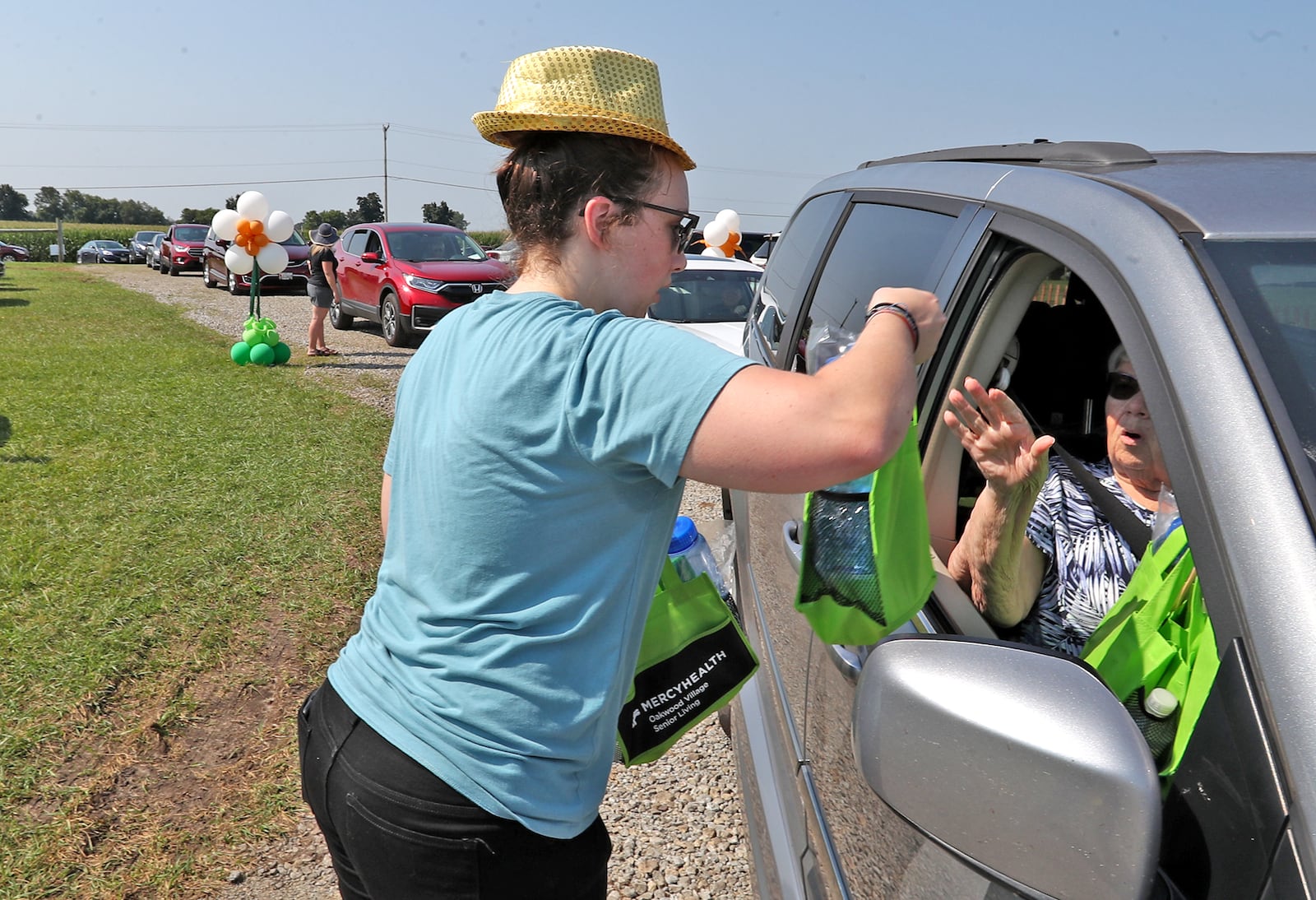 Jenna Bluemlein,  hands a couple gift bags through the car window for a Golden Anniversary Couple Tuesday at the Clark County Fair. BILL LACKEY/STAFF