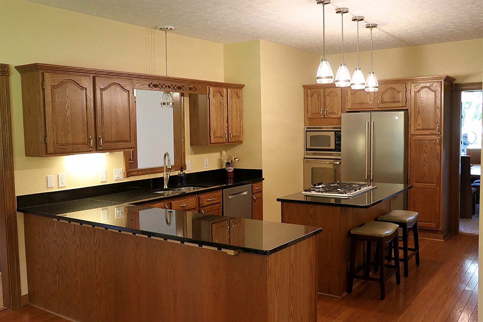 The kitchen has an abundance of cabinetry and dark granite countertops. There is a planning desk, coffee station, a pantry cabinet, a pantry closet, a peninsula counter to divide the kitchen from the breakfast room and an island with a gas cooktop. CONTRIBUTED PHOTO BY KATHY TYLER