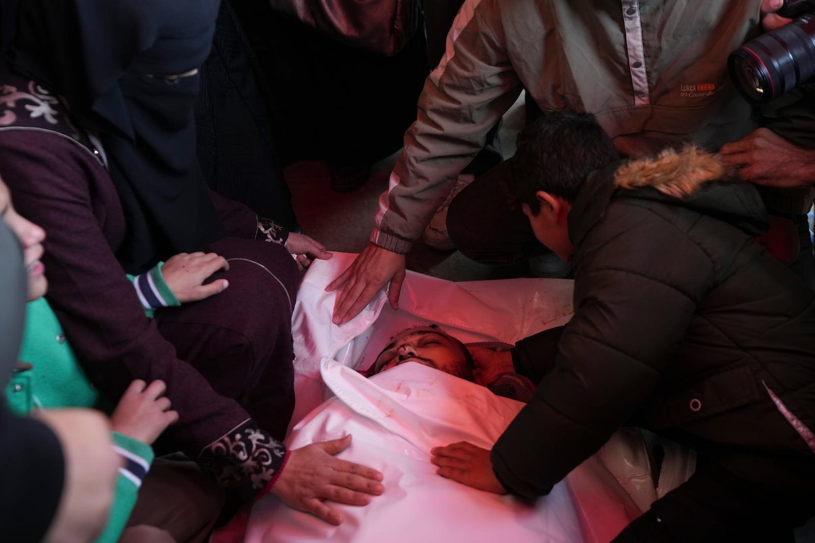 Palestinians mourn over the body of victim of an overnight Israeli strike, during a funeral in Deir al-Balah, Gaza Strip, Wednesday, Dec. 4, 2024. (AP Photo/Abdel Kareem Hana)