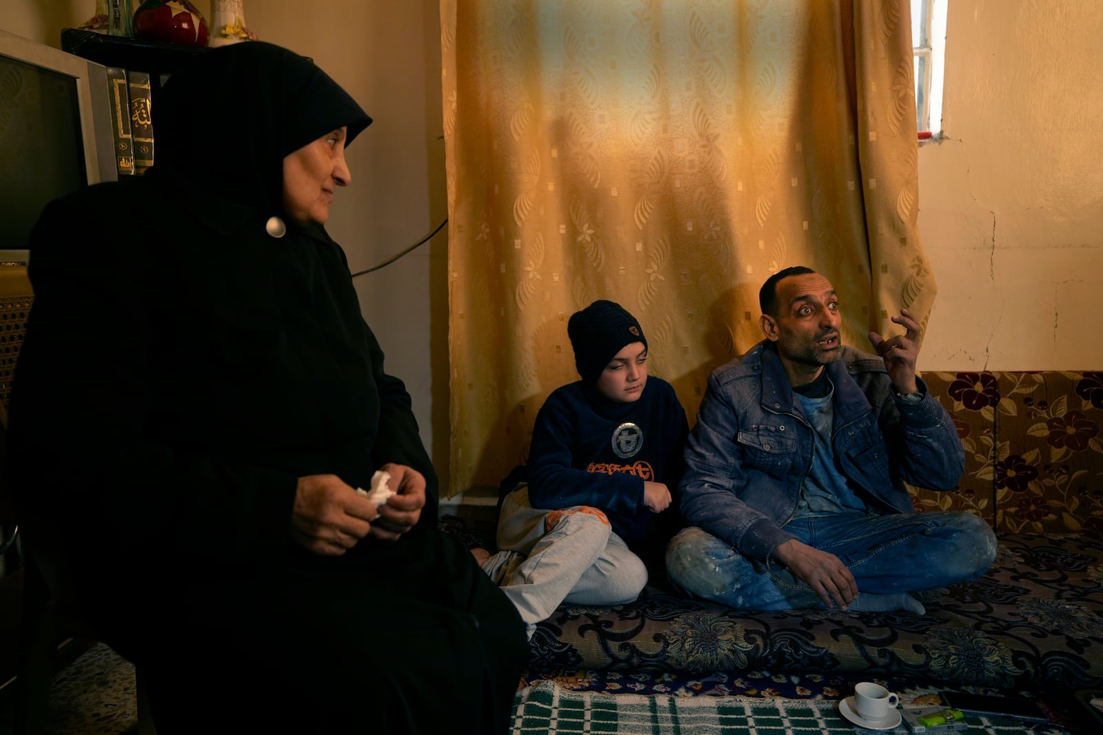 Hussein Arbeeni, 41, right, sits next of his mother mother Khadija Dabbas, 66, left, as he explains how he and his family suffered from the sarin struck during a 2013 chemical weapons attack that was blamed on then President Bashar Assad's forces, in Zamalka neighbourhood, on the outskirts of Damascus, Syria, Wednesday, Dec. 25, 2024. (AP Photo/Hussein Malla)