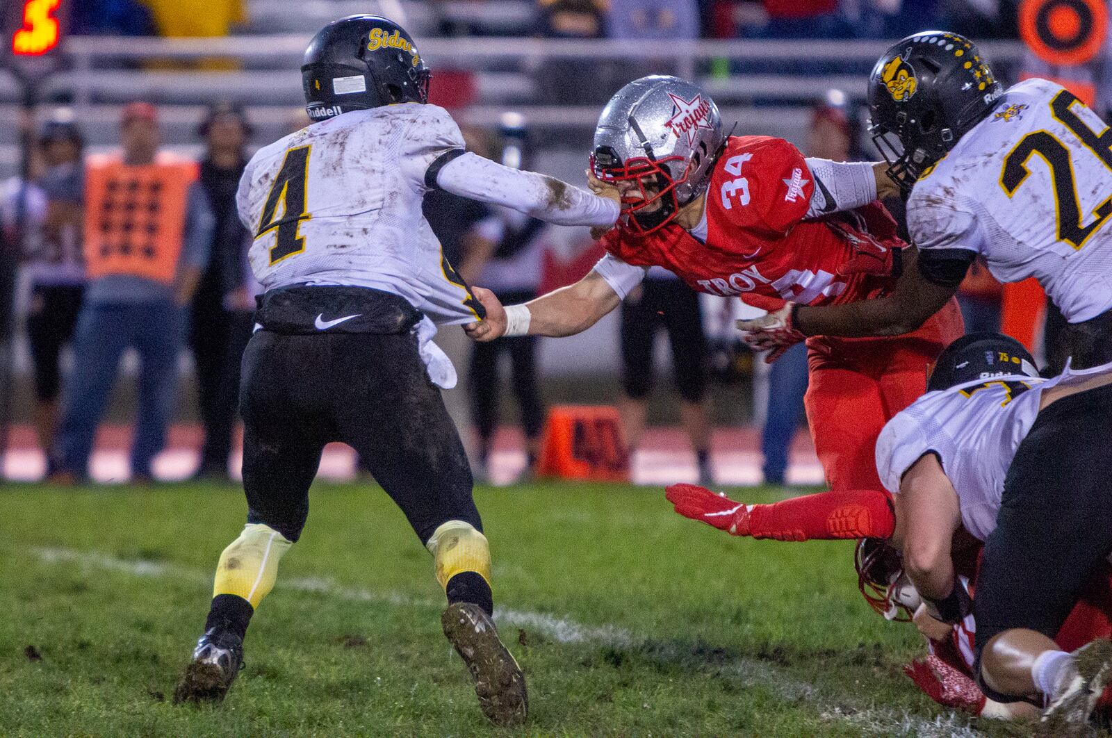 Sidney quarterback E.J. Davis tries to get outside of Troy's Curtis Valent (34) during the first half on Thursday, Sept. 23, 2021, in Troy. Photo by Jeff Gilbert