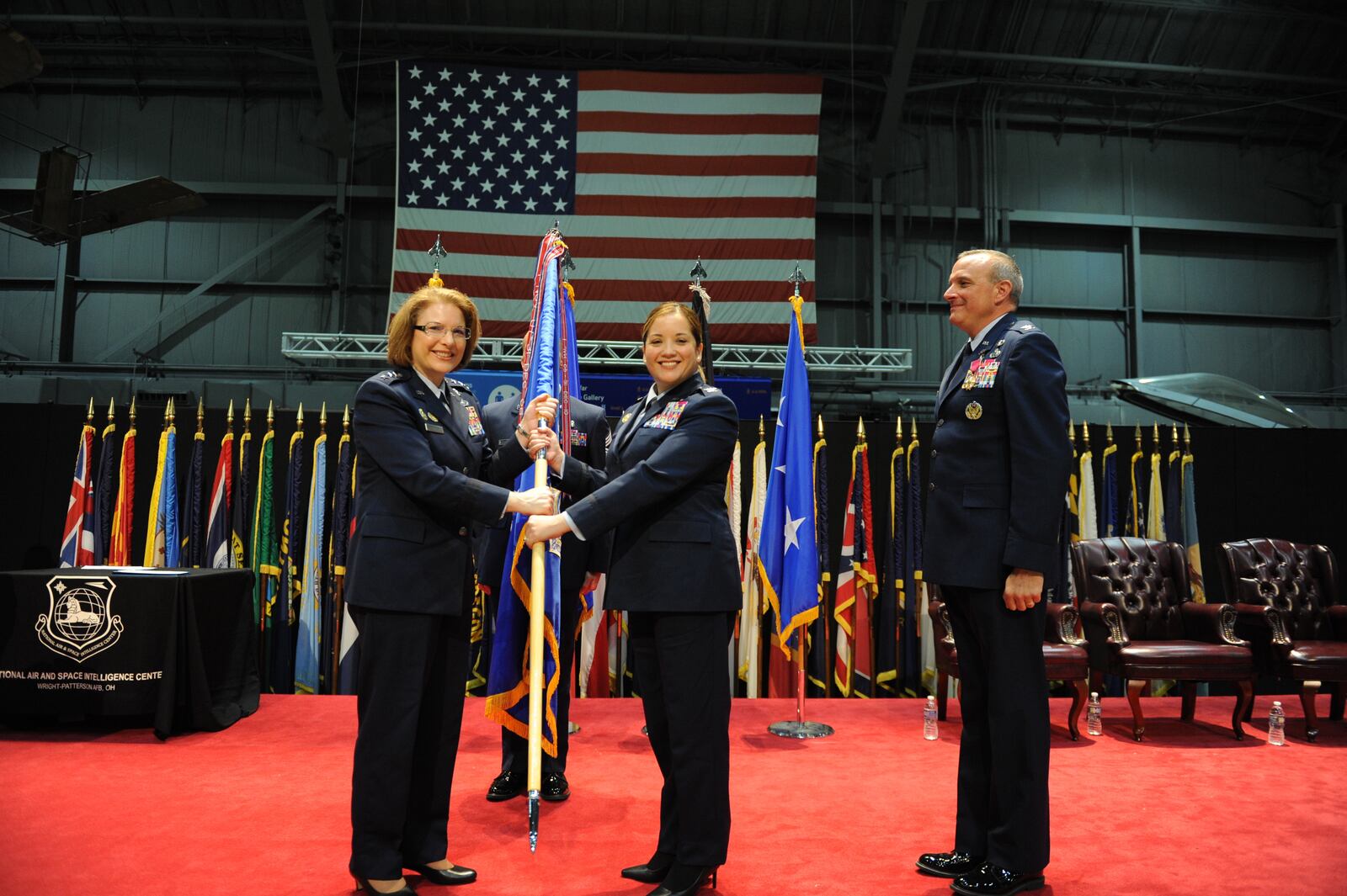 Col. Ariel Batungbacal (center) takes command of the National Air and Space Intelligence Center after receiving the guidon from Lt. Gen. Mary O’Brien, Deputy Chief of Staff for Intelligence, Surveillance, Reconnaissance and Cyber Effects Operations (left), during a ceremony at the National Museum of the United State Air Force, June 2, 2022. Former NASIC commander Col. Maurizio Calabrese is on the right. Air Force photo