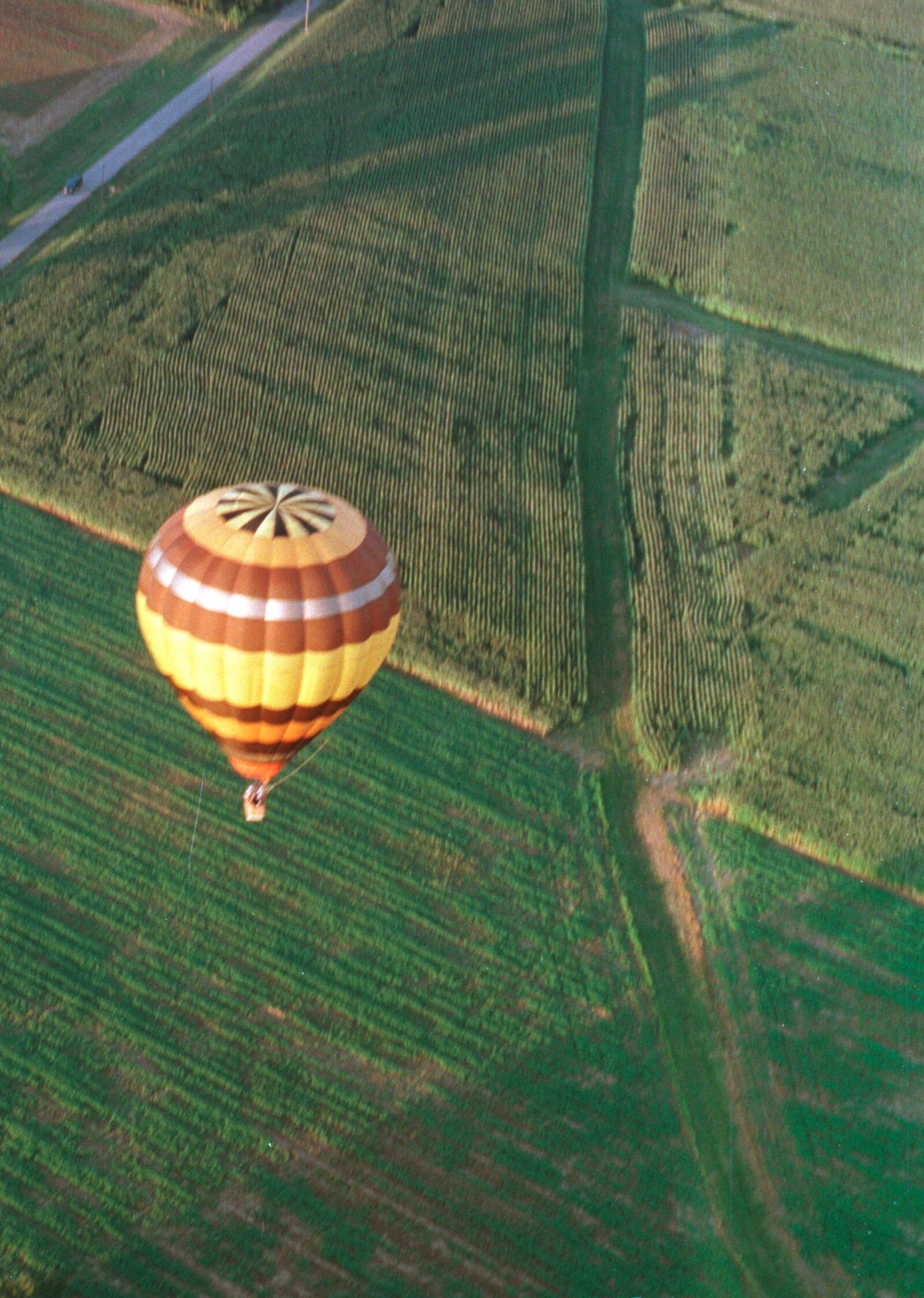 8-19-98 -- A hot air balloon floats over the farm fields of Clear Creek Twp in the late evening sun where the crops make patterns in the earth. With the nice morning and evening weather on Wednesday and Thursday, many balloonists have taken advantage of the calm winds and clear skies to fly over the Miami Valley.  Ty Greenlees/DDN