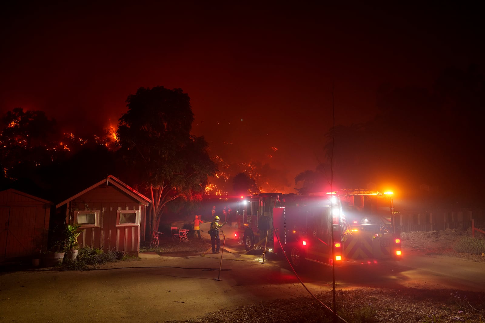 Firefighters protect a structure as the Franklin Fire approaches in Malibu, Calif., Tuesday, Dec. 10, 2024. (AP Photo/Eric Thayer)