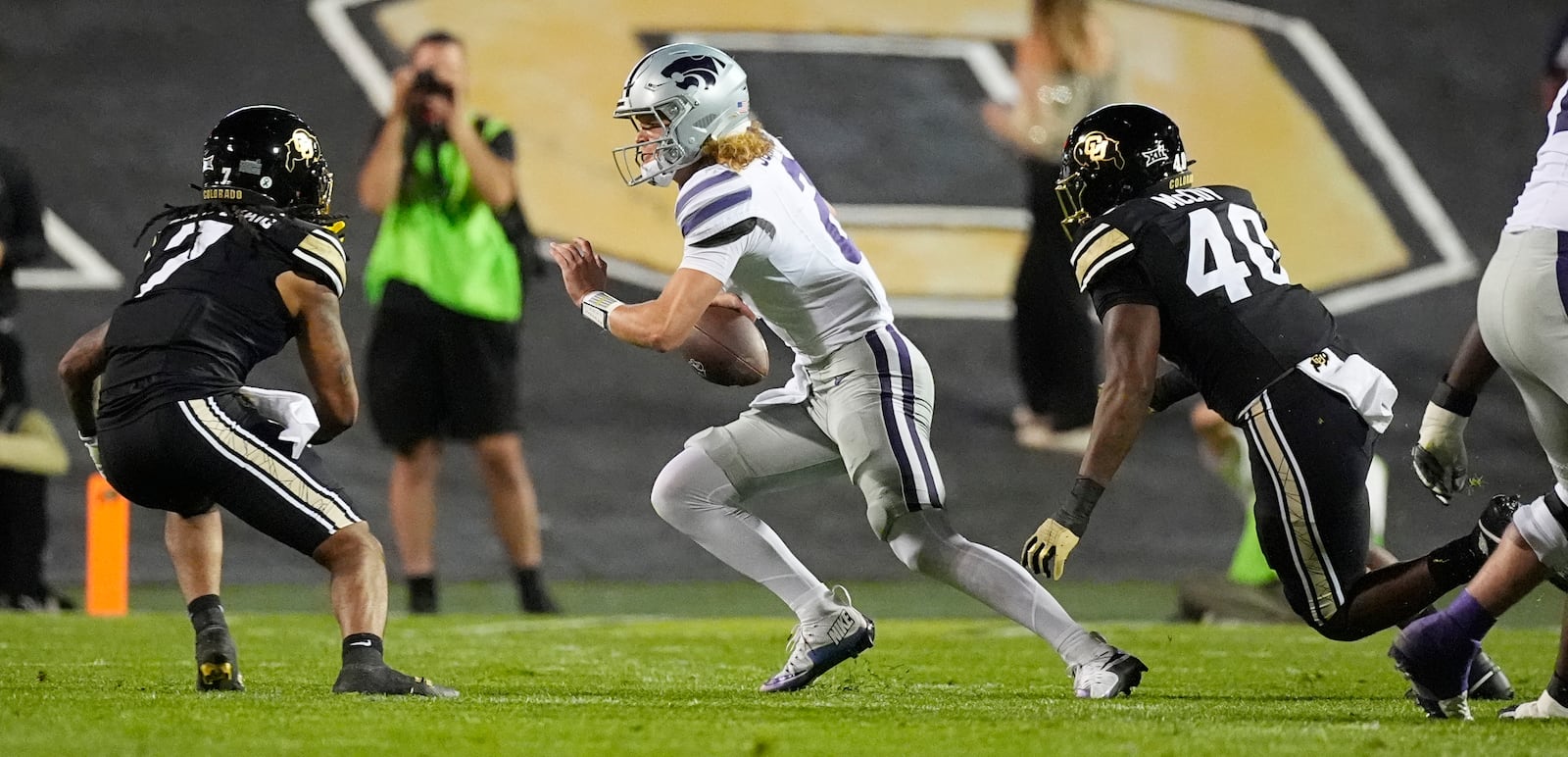 Kansas State quarterback Avery Johnson, center, is pursued by Colorado safety Cam'Ron Silmon-Craig, left, and defensive end Taje McCoy in the first half of an NCAA college football game Saturday, Oct. 12, 2024, in Boulder, Colo. (AP Photo/David Zalubowski)