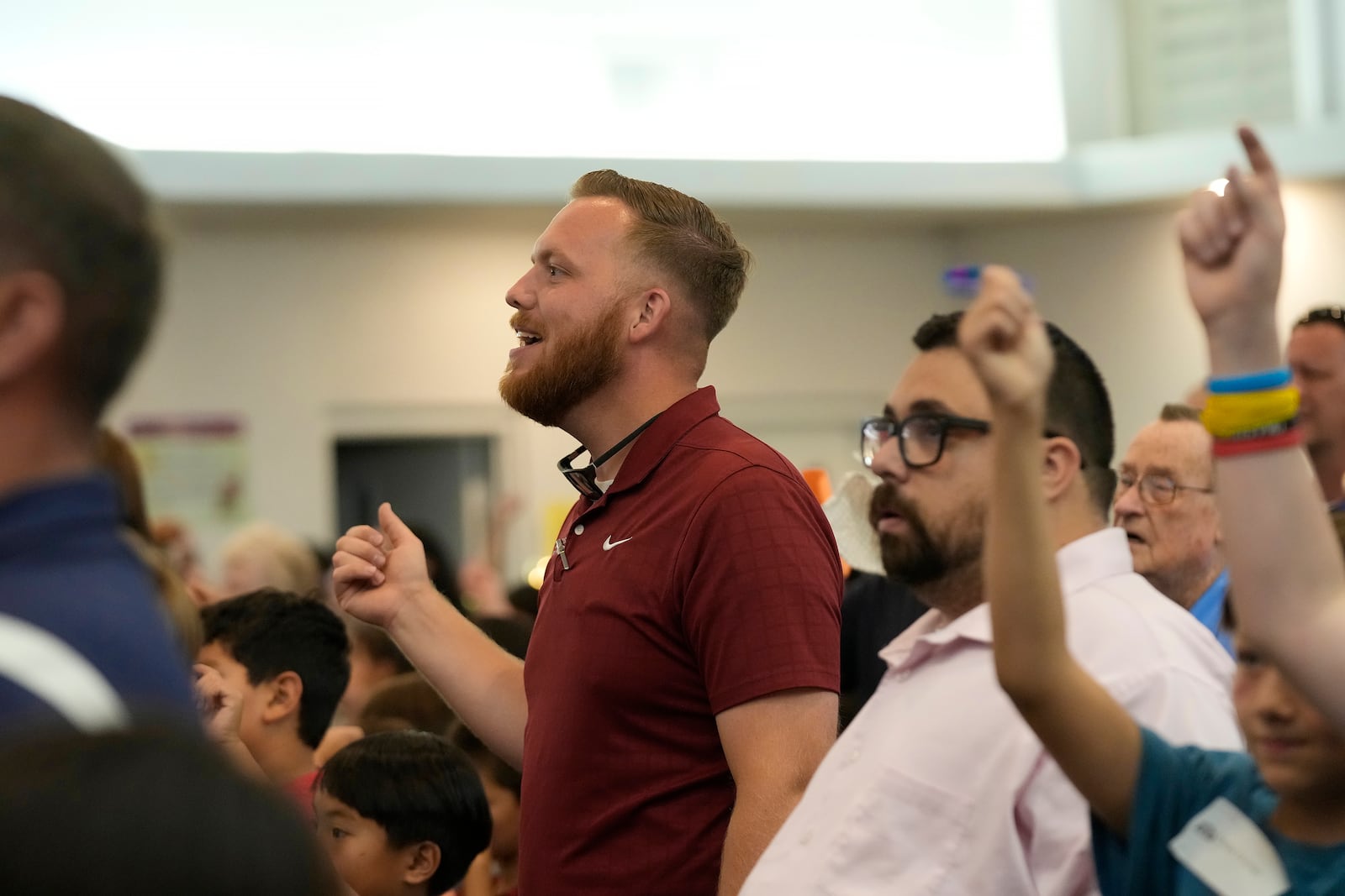 Trevor Cowling, left, and Karl Peterson, right, participate in a service during a summer camp for youth at Valley Baptist Church, Tuesday, June 18, 2024, in Mesa, Ariz. (AP Photo/Ross D. Franklin)