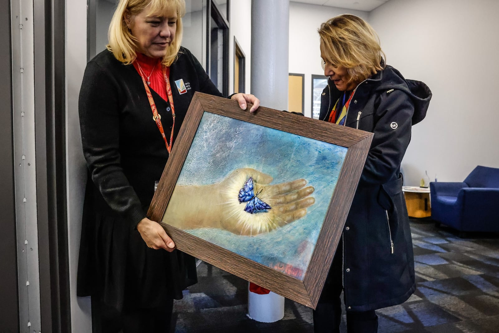 Deputy Executive Director of the Dayton Metro Library, Rachel Gut, left, excepts work from Martha Jeannette Rodriguez who is from Columbia South America. JIM NOELKER/STAFF