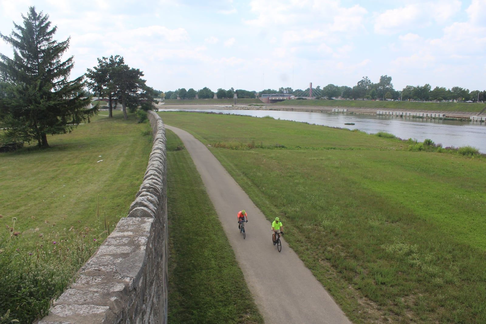 Cyclists ride along the Miami River at the edge of downtown Dayton. The Dayton Riverfront Plan calls for constructing a new pedestrian bridge, a new park and other amenities along the river. CORNELIUS FROLIK / STAFF