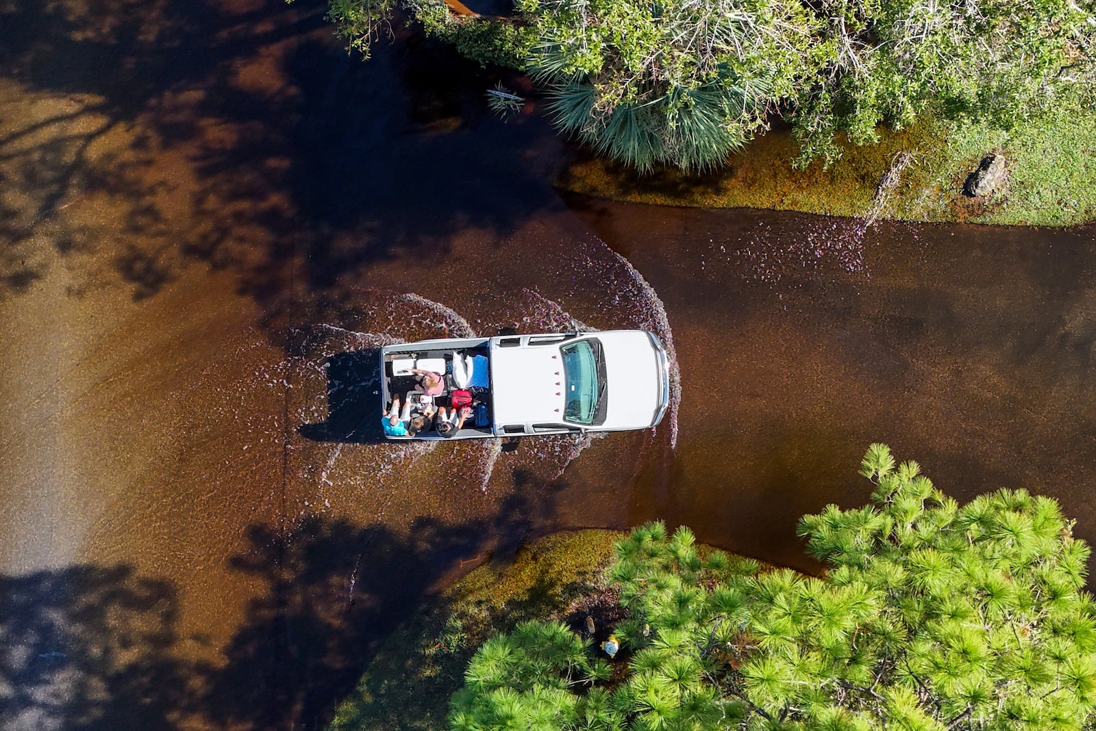 Two couples who evacuated get a ride back to their home through flooding after Hurricane Milton hit the region, Thursday, Oct. 10, 2024, in Palm Harbor, Fla. (AP Photo/Mike Carlson)