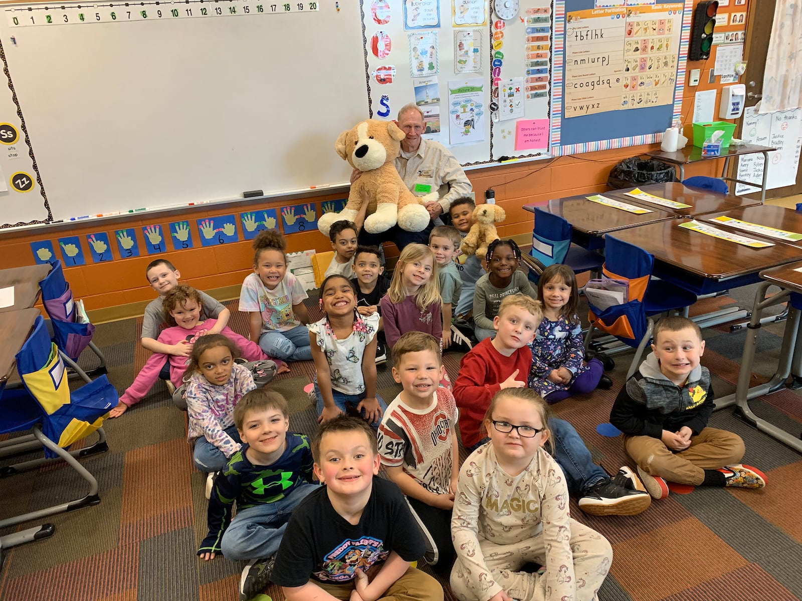 Dr. Coatney (rear holding stuffed dog) reading his first book to Sarah Hacker's kindergarten class at Arrowood Elementary School in Xenia in February of 2024.