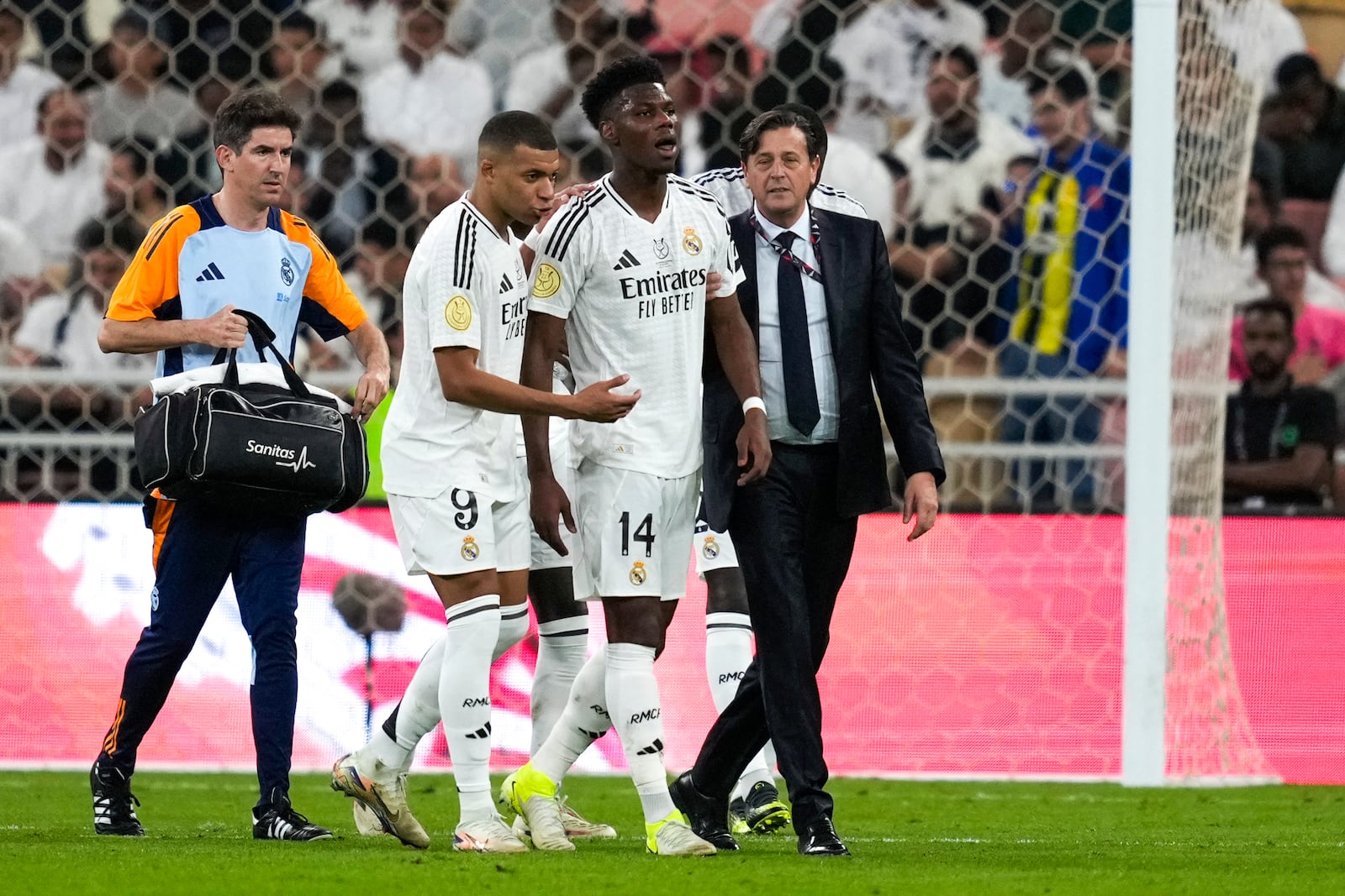 Real Madrid's Aurelien Tchouameni, centre, walks out of field after an injury during the Spanish Super Cup semifinal soccer match between Real Madrid and Mallorca at the King Abdullah Stadium in Jeddah, Saudi Arabia, Thursday, Jan. 9, 2025. (AP Photo/Altaf Qadri)