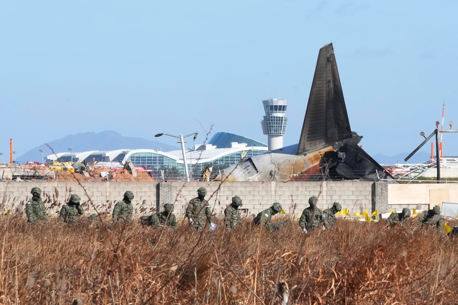 South Korean army soldiers work outside of Muan International Airport in Muan, South Korea, Tuesday, Dec. 31, 2024, following Sunday's plane crash. (AP Photo/Ahn Young-joon)