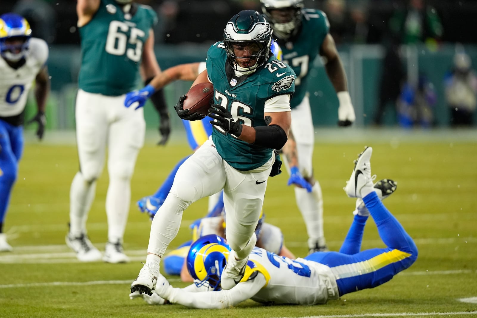 Philadelphia Eagles running back Saquon Barkley (26) runs the ball for a touchdown during the first half of an NFL football NFC divisional playoff game against the Los Angeles Rams on Sunday, Jan. 19, 2025, in Philadelphia. (AP Photo/Chris Szagola)