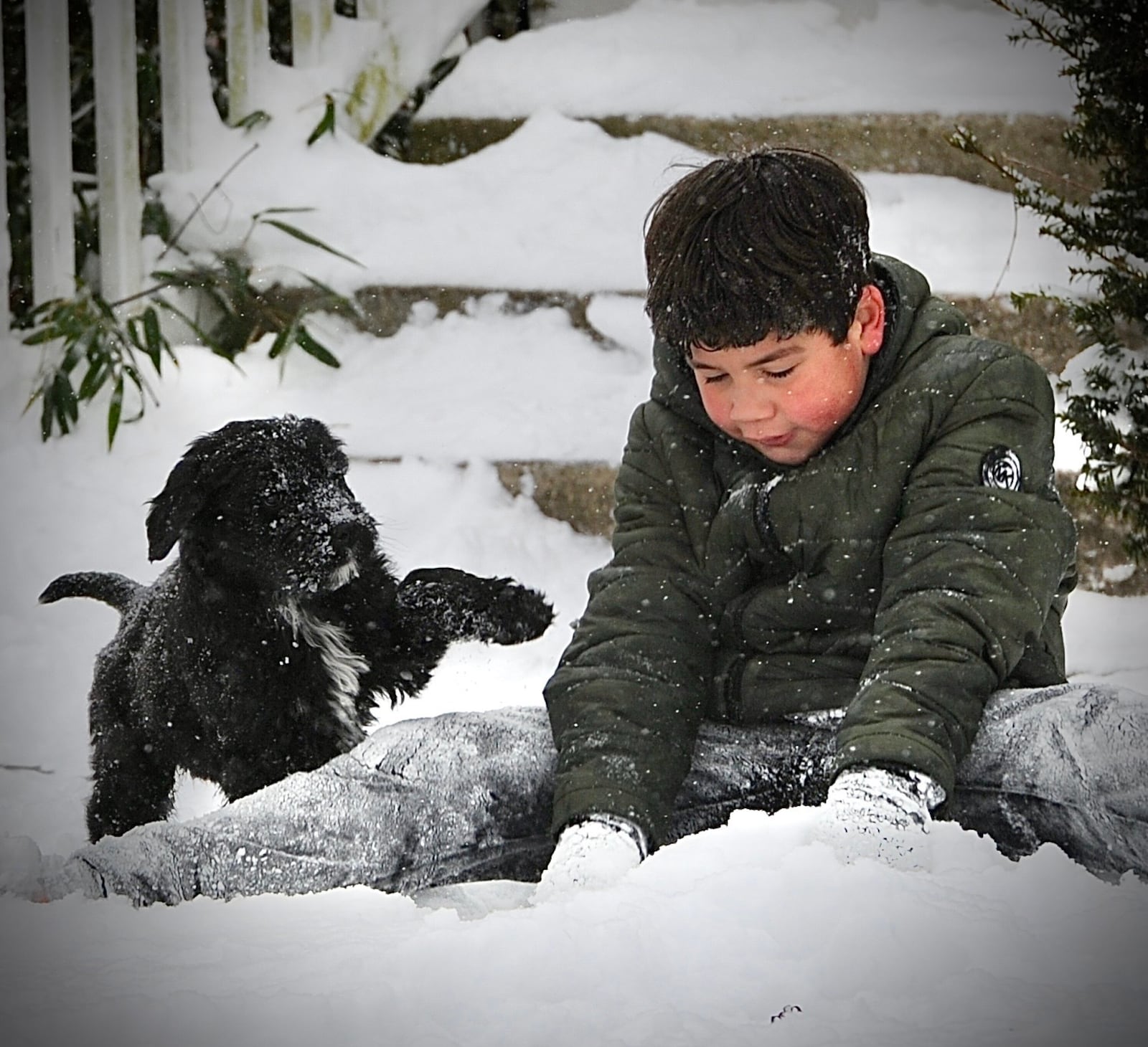 Liam Lewis, 9, plays in the snow with his puppy Shadow, Friday February 4, 2022.