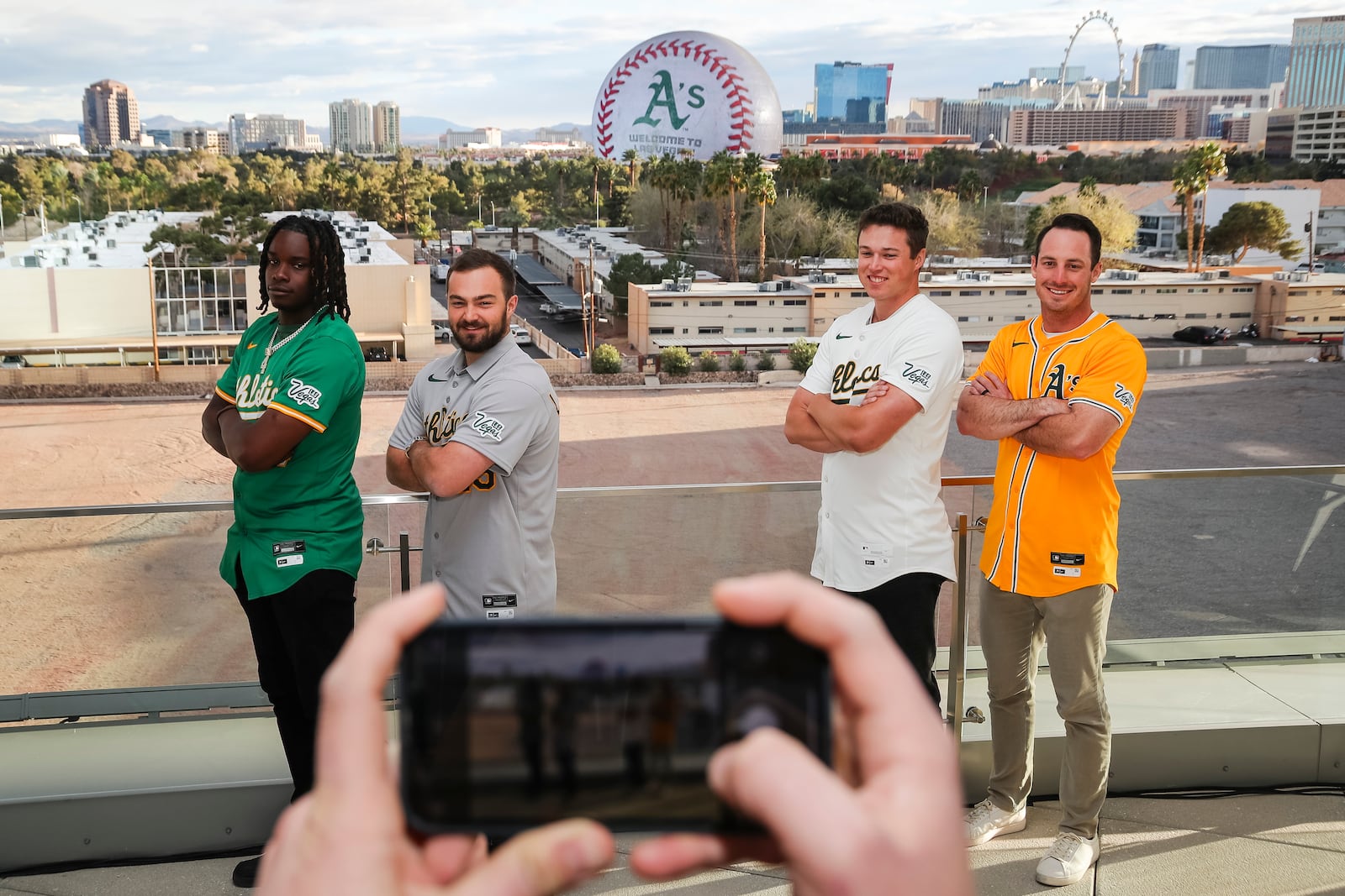 Athletics players, from left, Lawrence Butler, Shea Langeliers, Mason Miller and Brent Rooker pose for a photo as their team's logo is displayed on The Sphere during a press conference, Friday, March 7, 2025, in Las Vegas. (Wade Vandervort//Las Vegas Sun via AP)