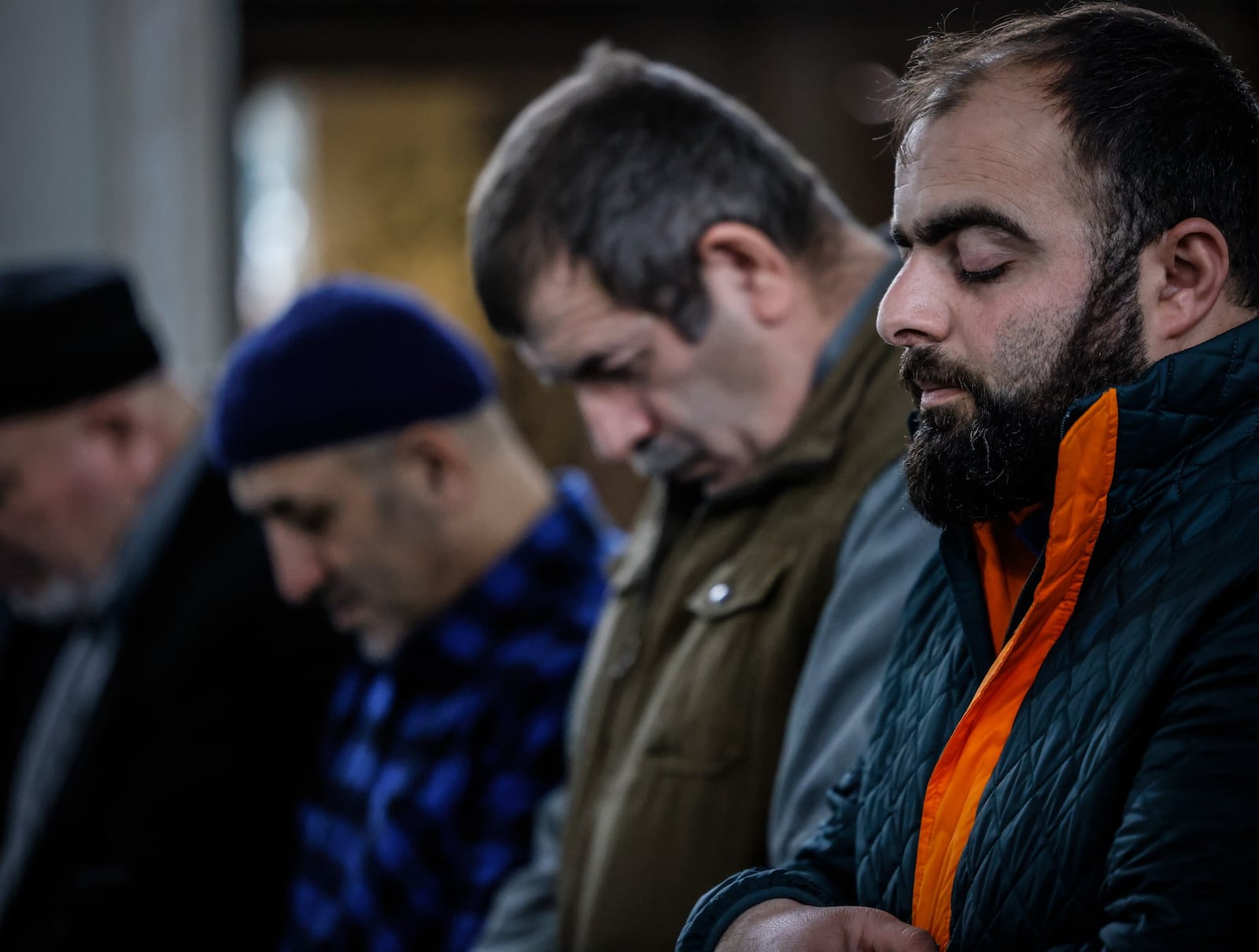 Mirza Mirza, far right, prays with other Dayton Ahiska Turks at their mosque on Valley St. in Dayton. Many of Dayton's Ahiska Turks have relatives in Ukraine and fear for their safety. JIM NOELKER/STAFF