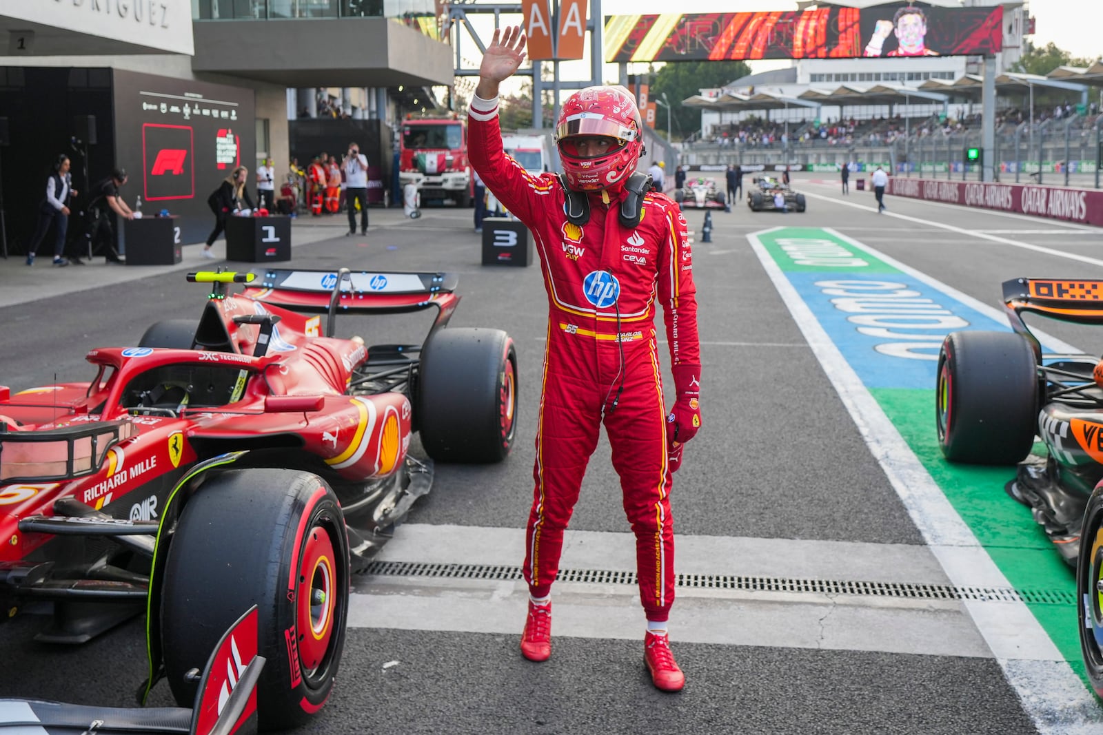 Ferrari driver Carlos Sainz, of Spain, waves after winning the pole position for the Formula One Mexico Grand Prix auto race at the Hermanos Rodriguez racetrack in Mexico City, Saturday, Oct. 26, 2024. (AP Photo/Fernando Llano)