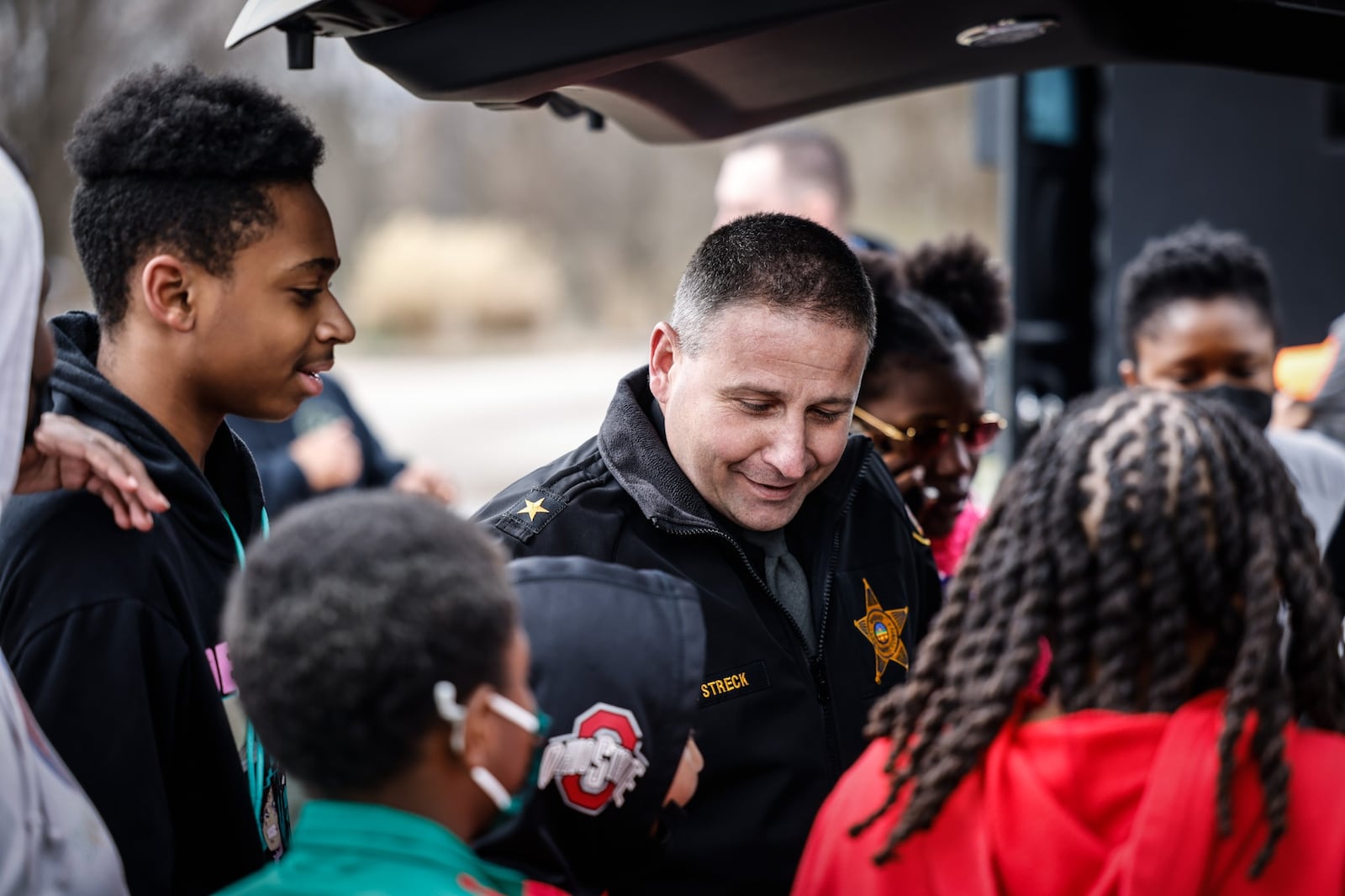 Montgomery County Sheriff Rob Streck shows some Dayton-area kids what a sheriff deputy carries in the back of their vehicle. Police and Youth Together on Thursday, March 24 held a spring break camp at the Dayton FOP lodge on Powell Road. Organizers said they hoped the camp strengthen the relationship between the community and police. JIM NOELKER/STAFF