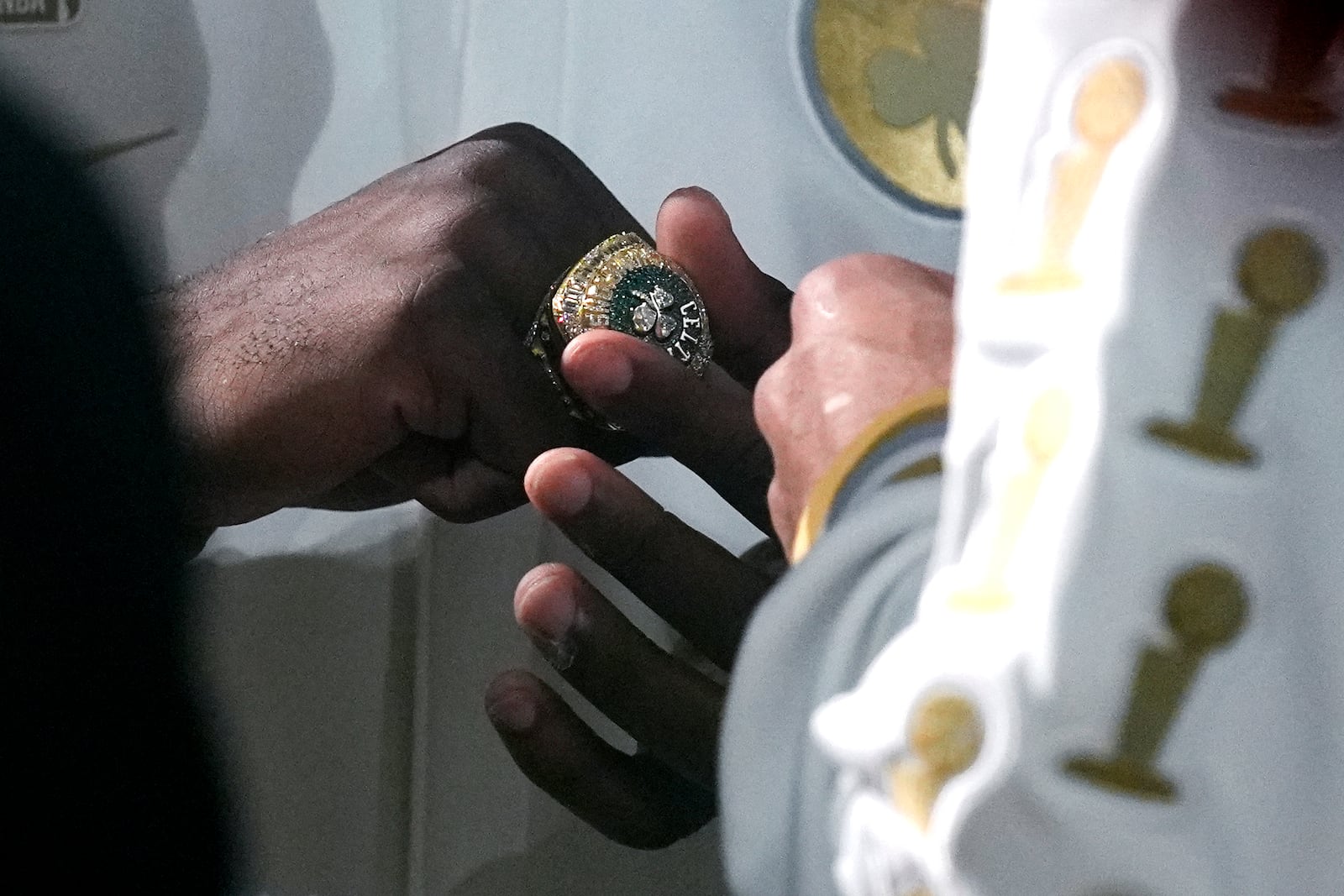 Boston Celtics guard Jaylen Brown admires his ring as the 2024 World Championship banner is raised prior to an NBA basketball game against the New York Knicks, Tuesday, Oct. 22, 2024, in Boston. (AP Photo/Charles Krupa)